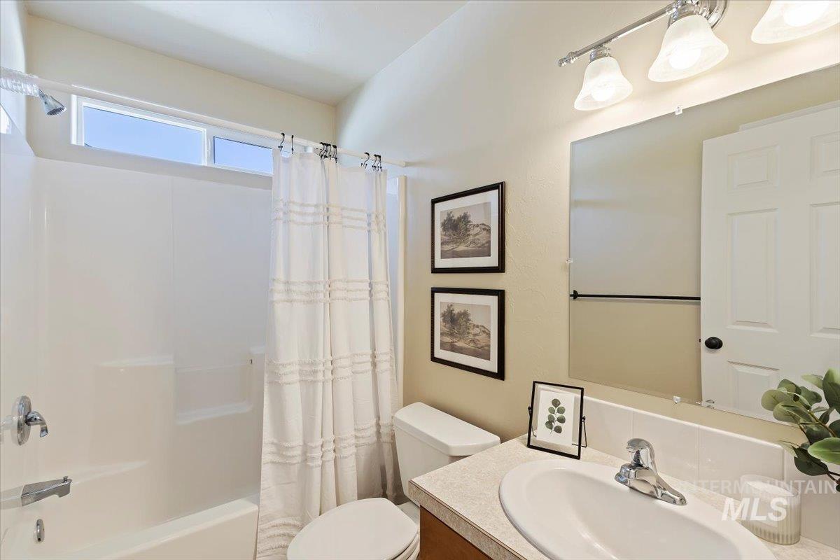 Bathroom with shower / tub combo with curtain and vanity