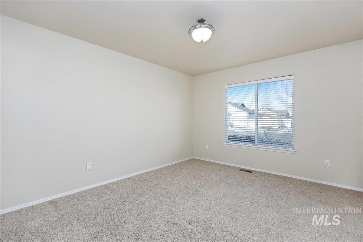 Carpeted spare room with baseboards