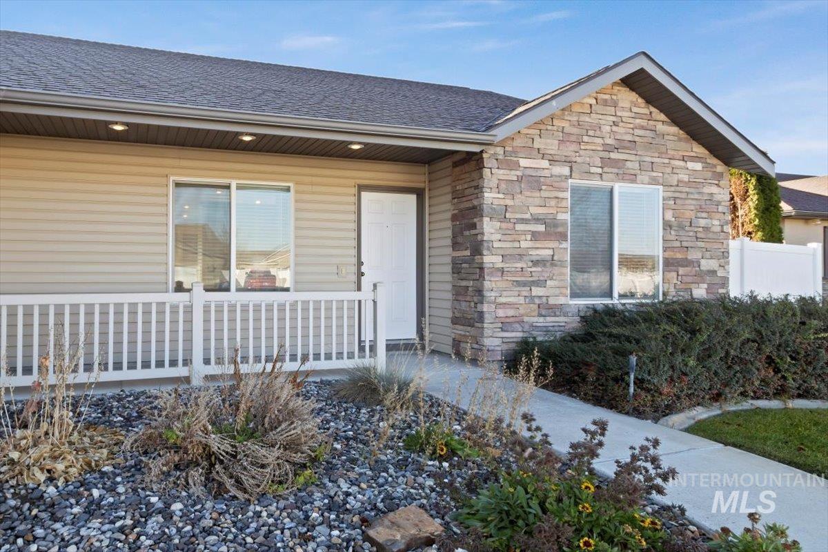 Entrance to property featuring roof with shingles and stone siding