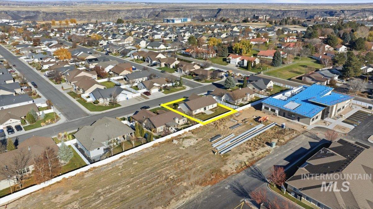 Aerial view of property and surrounding area with nearby suburban area