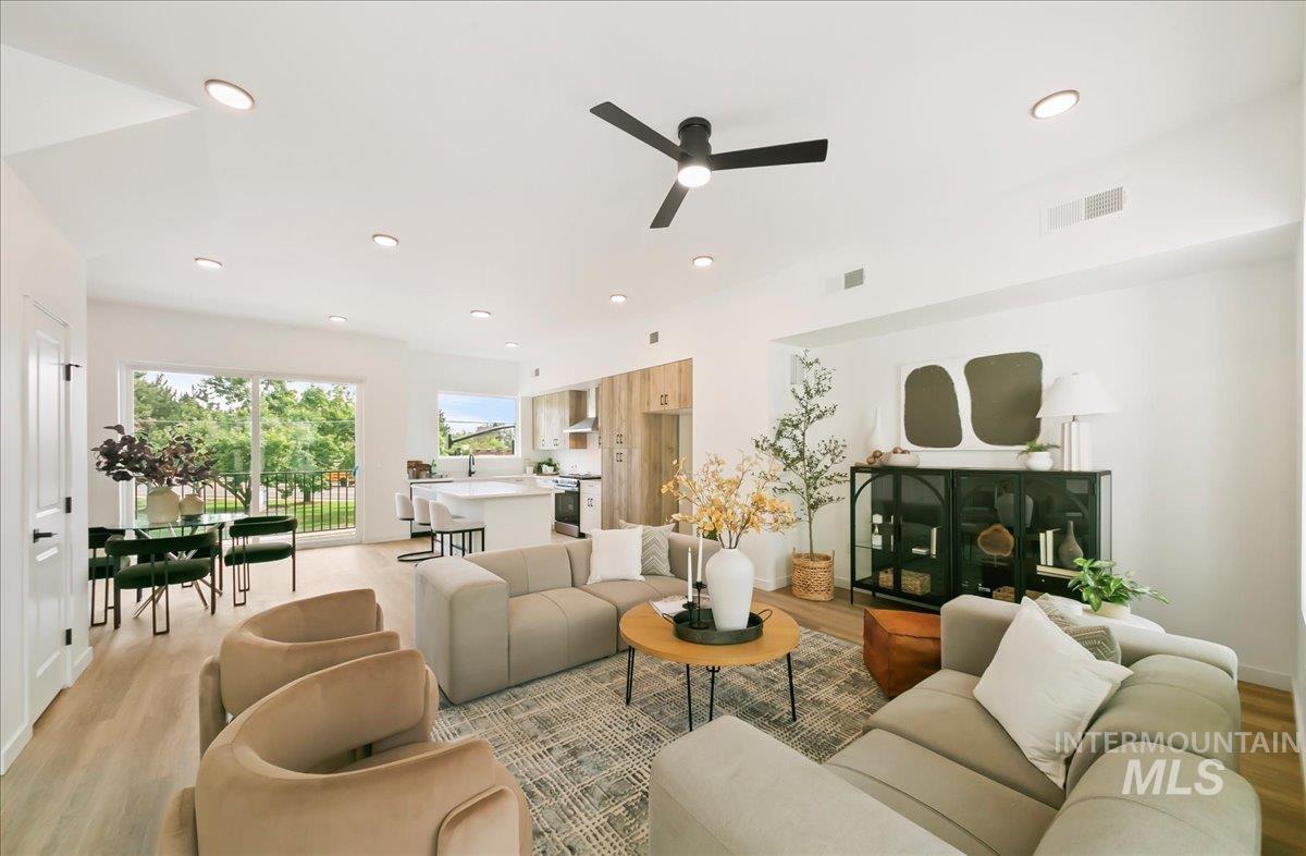Living room with light wood-style flooring, a ceiling fan, and recessed lighting