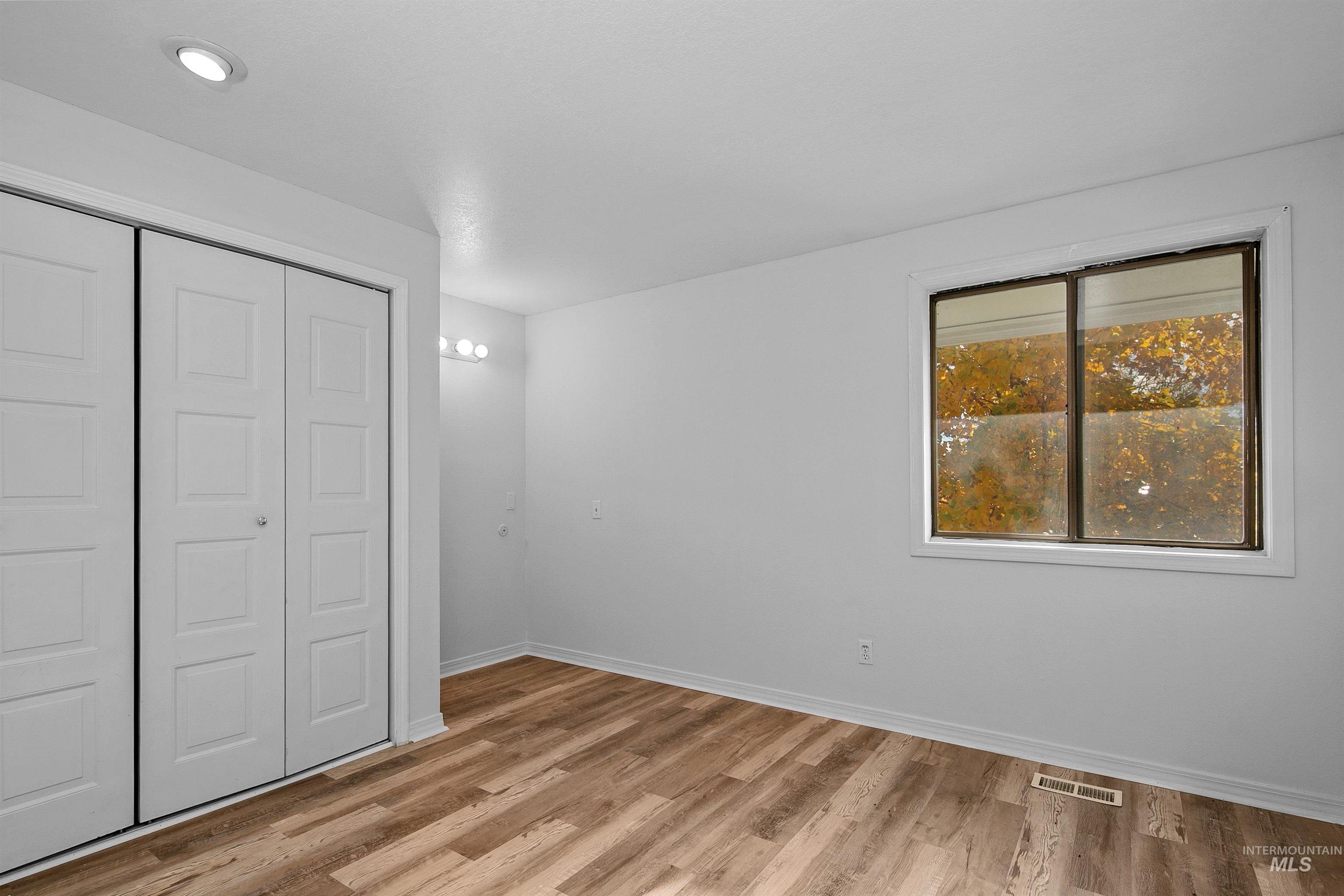 Unfurnished bedroom with a closet and light wood-style floors