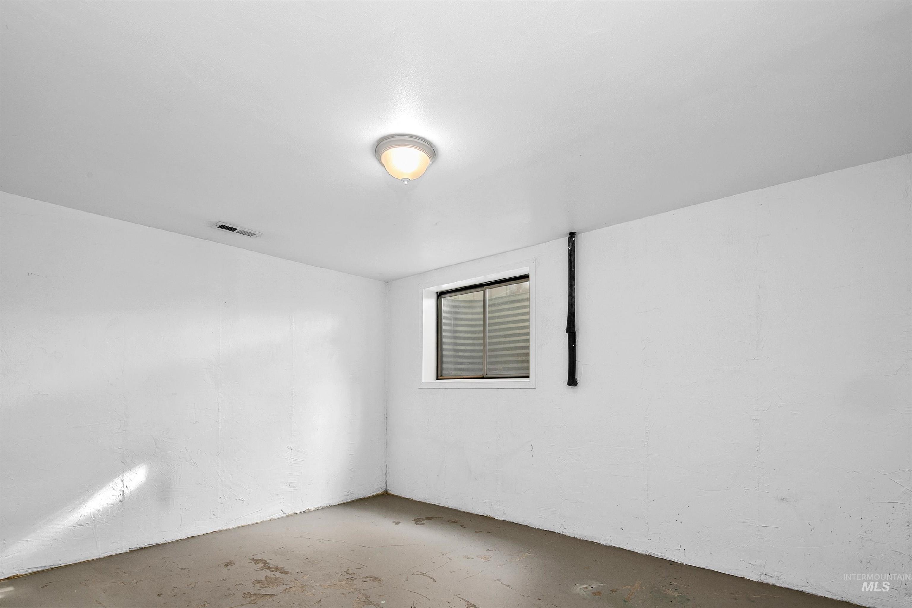Spare room featuring unfinished concrete flooring
