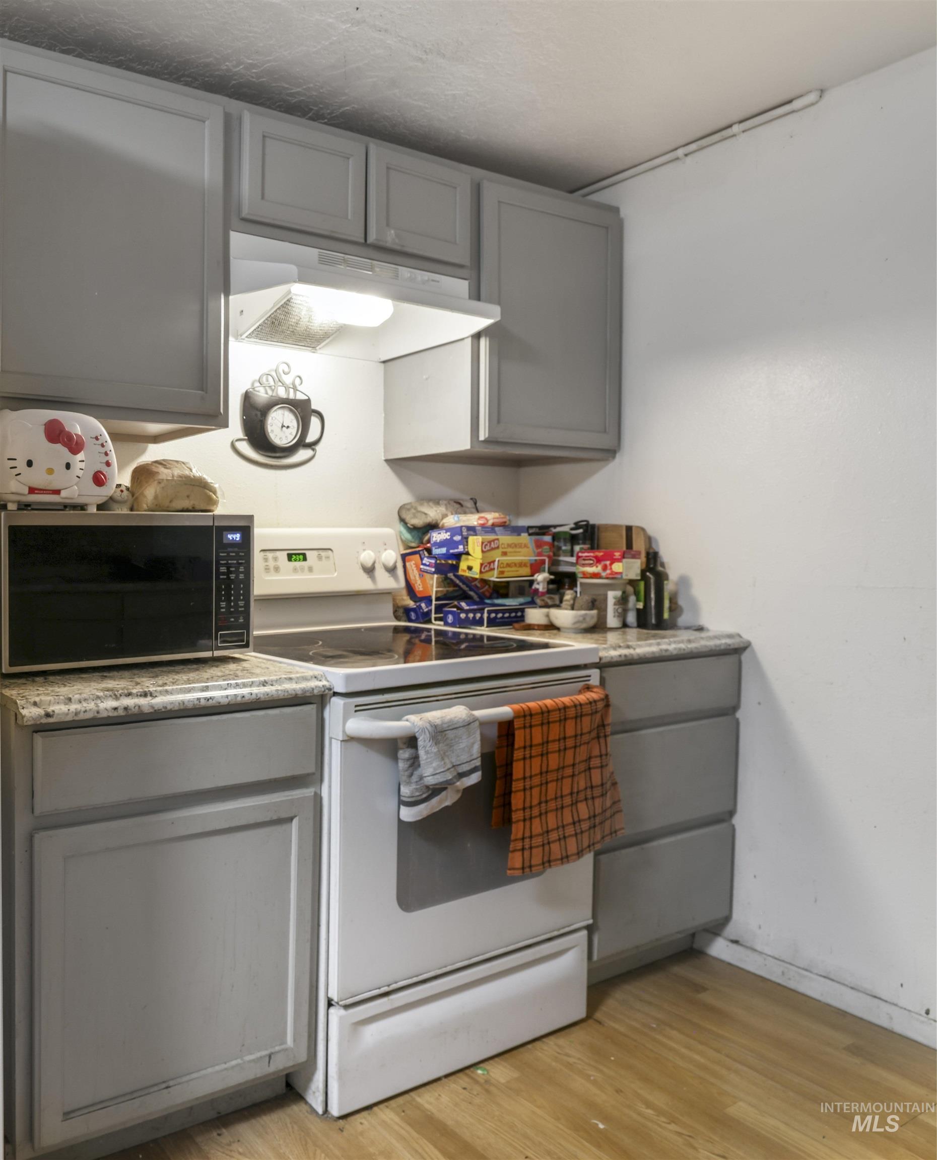 Kitchen featuring gray cabinetry and white electric range