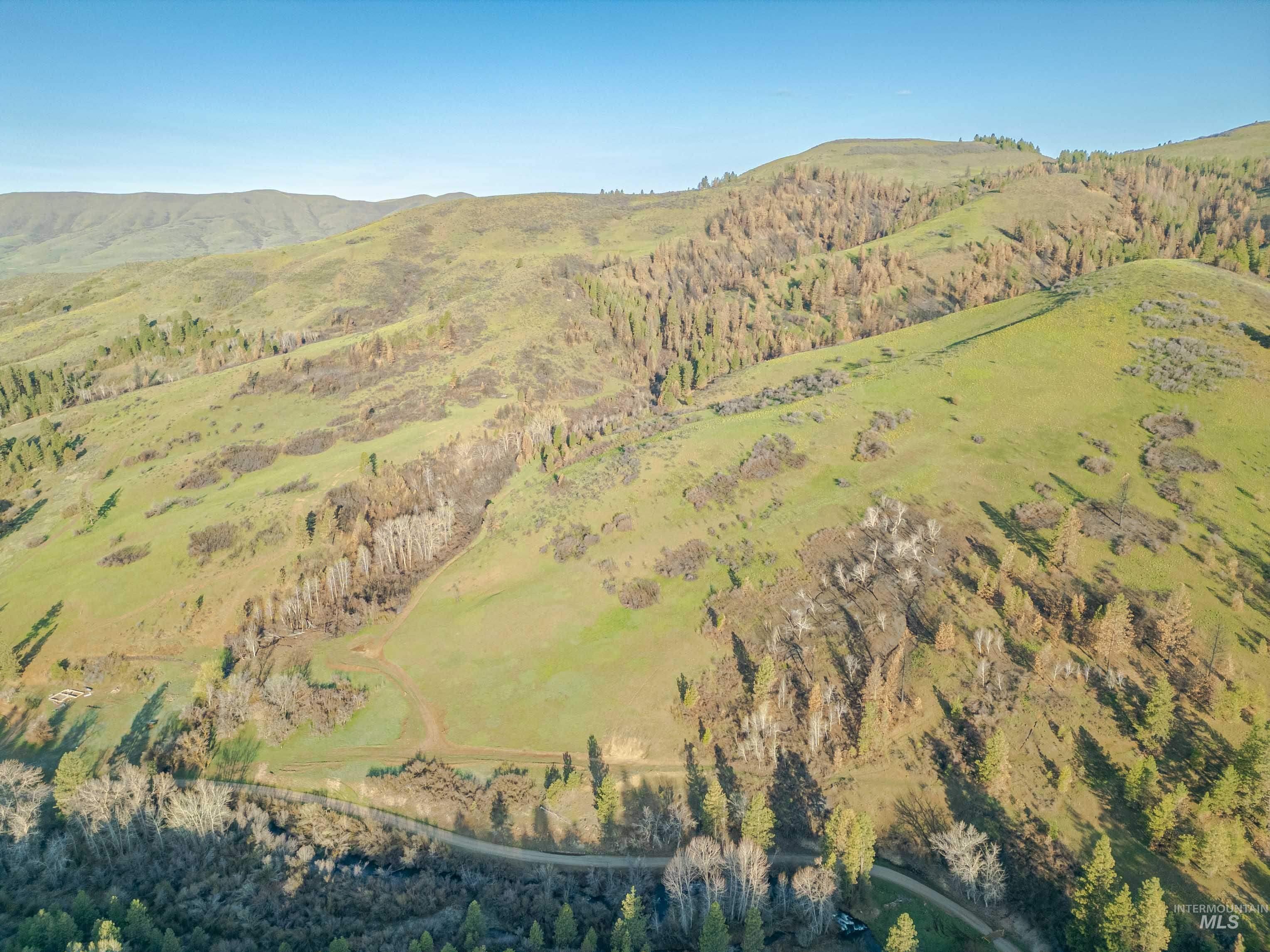 Aerial view of property and surrounding area featuring mountains