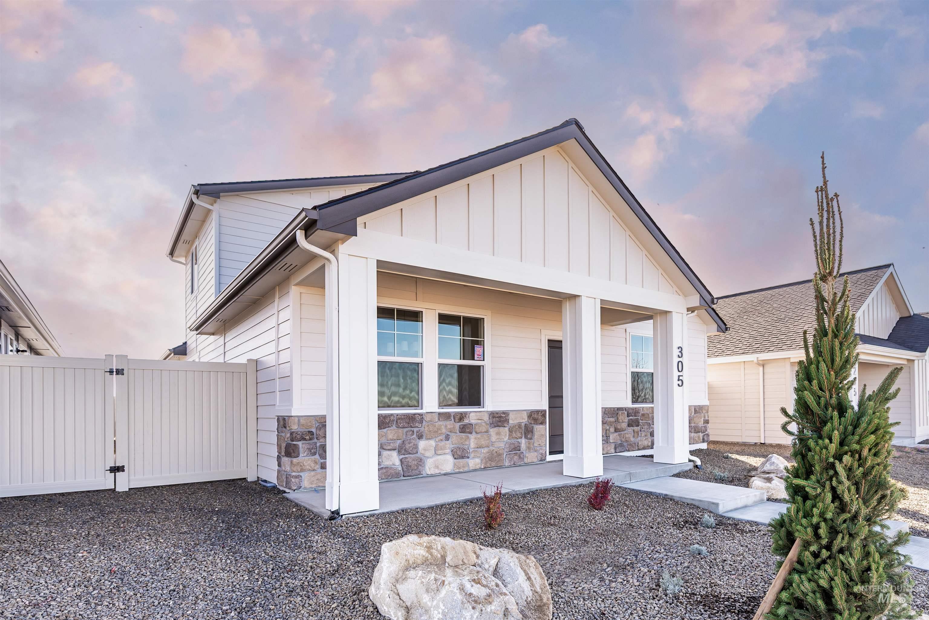 View of front of home with covered porch, board and batten siding, and a gate