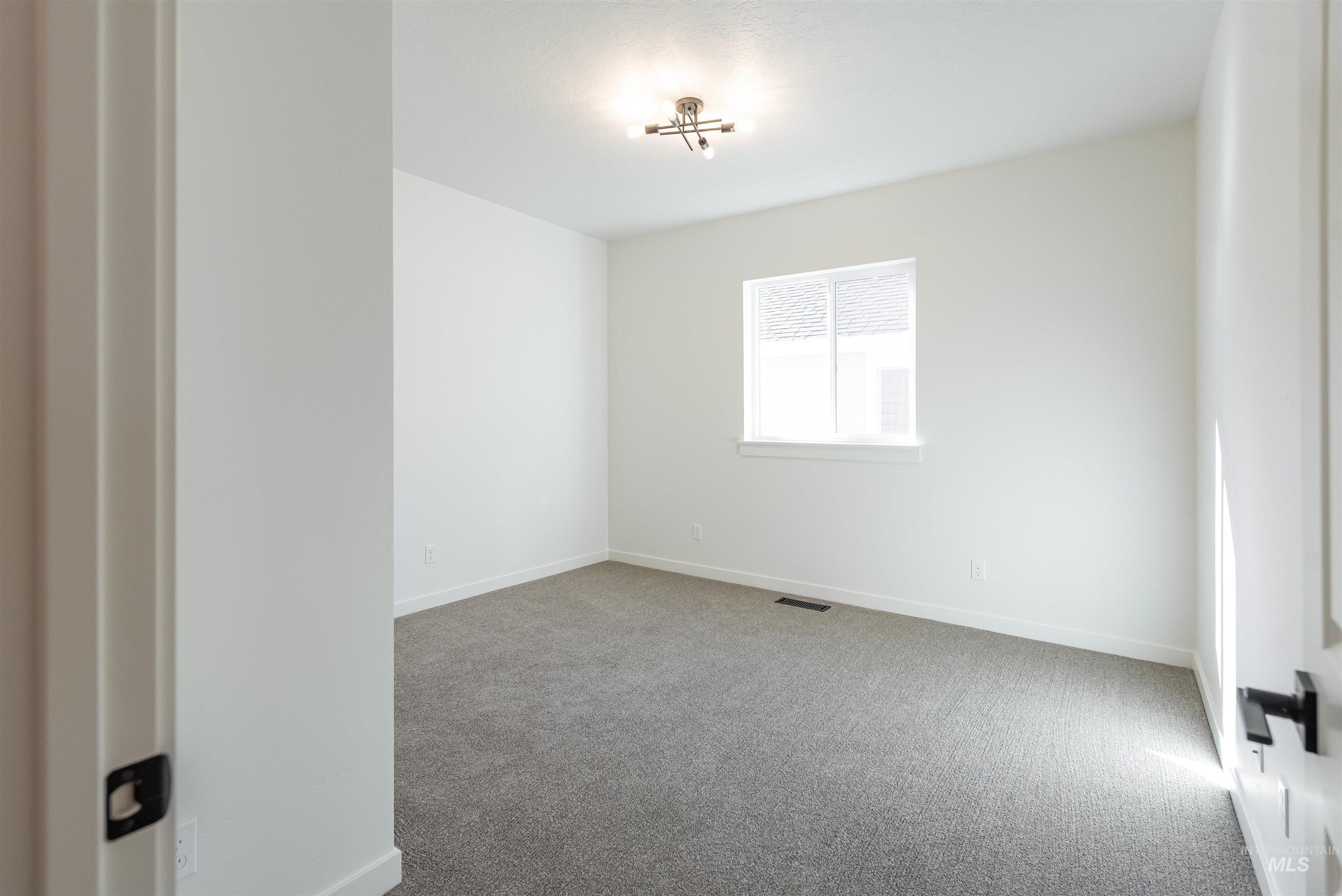 Spare room with light carpet and baseboards