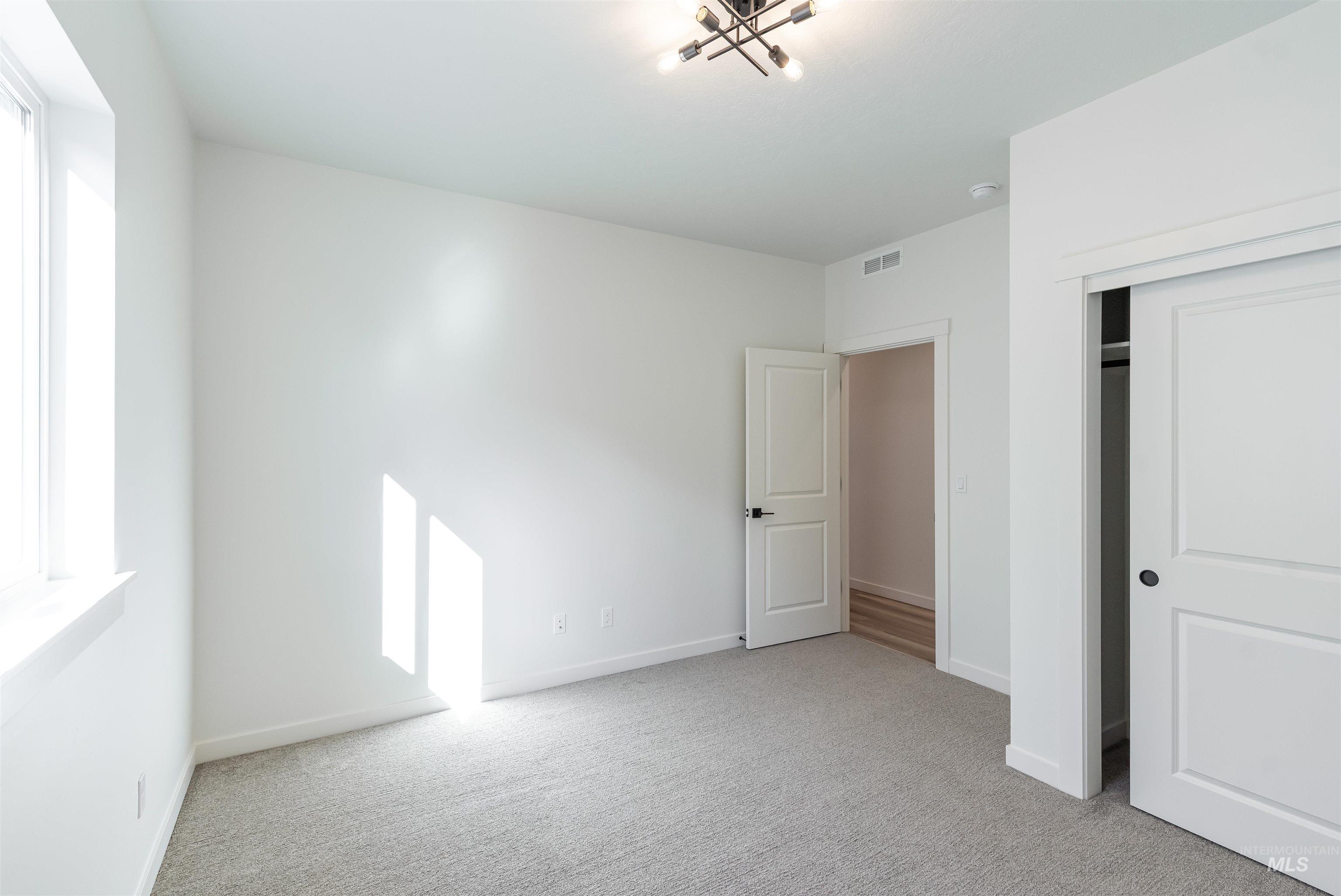 Unfurnished bedroom featuring light colored carpet and a closet