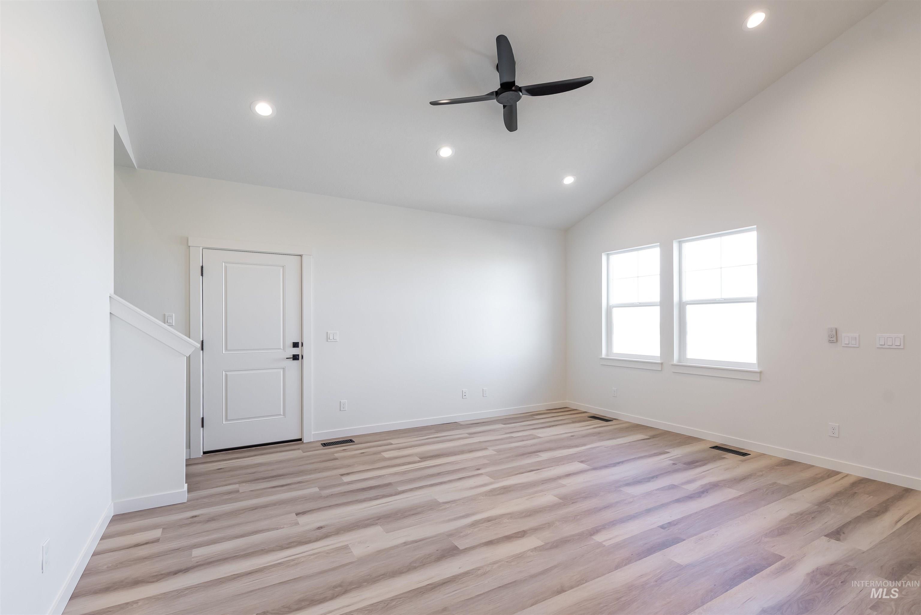 Unfurnished room with light wood-style flooring, vaulted ceiling, recessed lighting, and ceiling fan