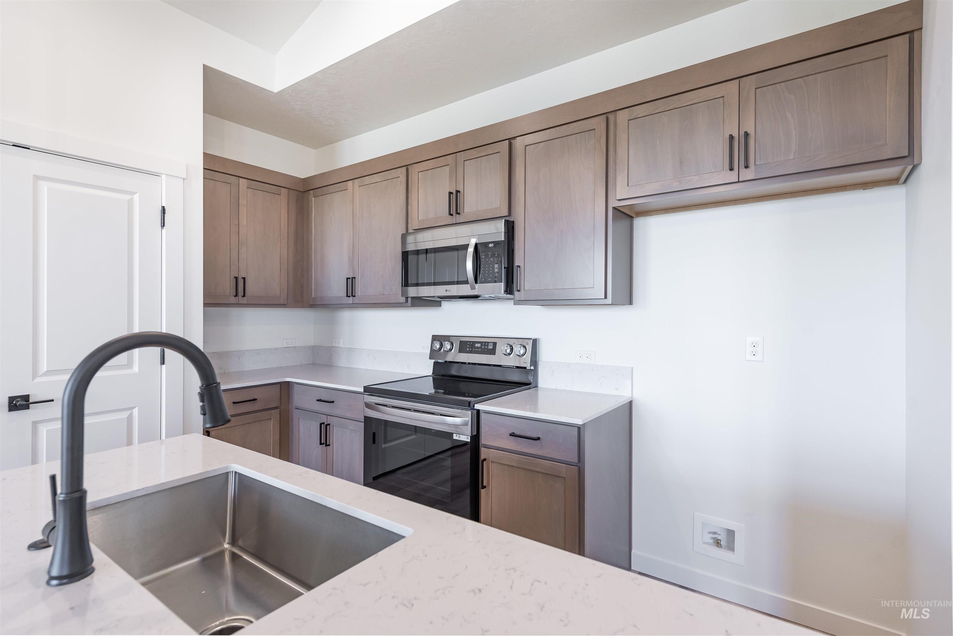 Kitchen featuring stainless steel appliances and light stone countertops