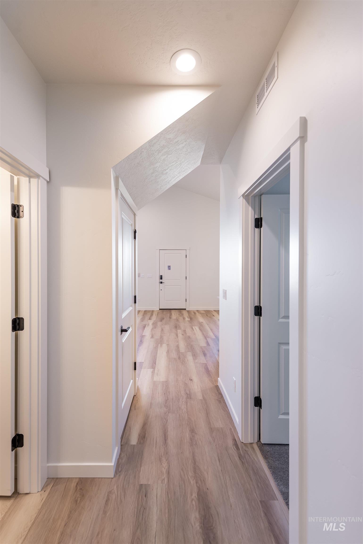 Hall featuring lofted ceiling and light wood-style floors
