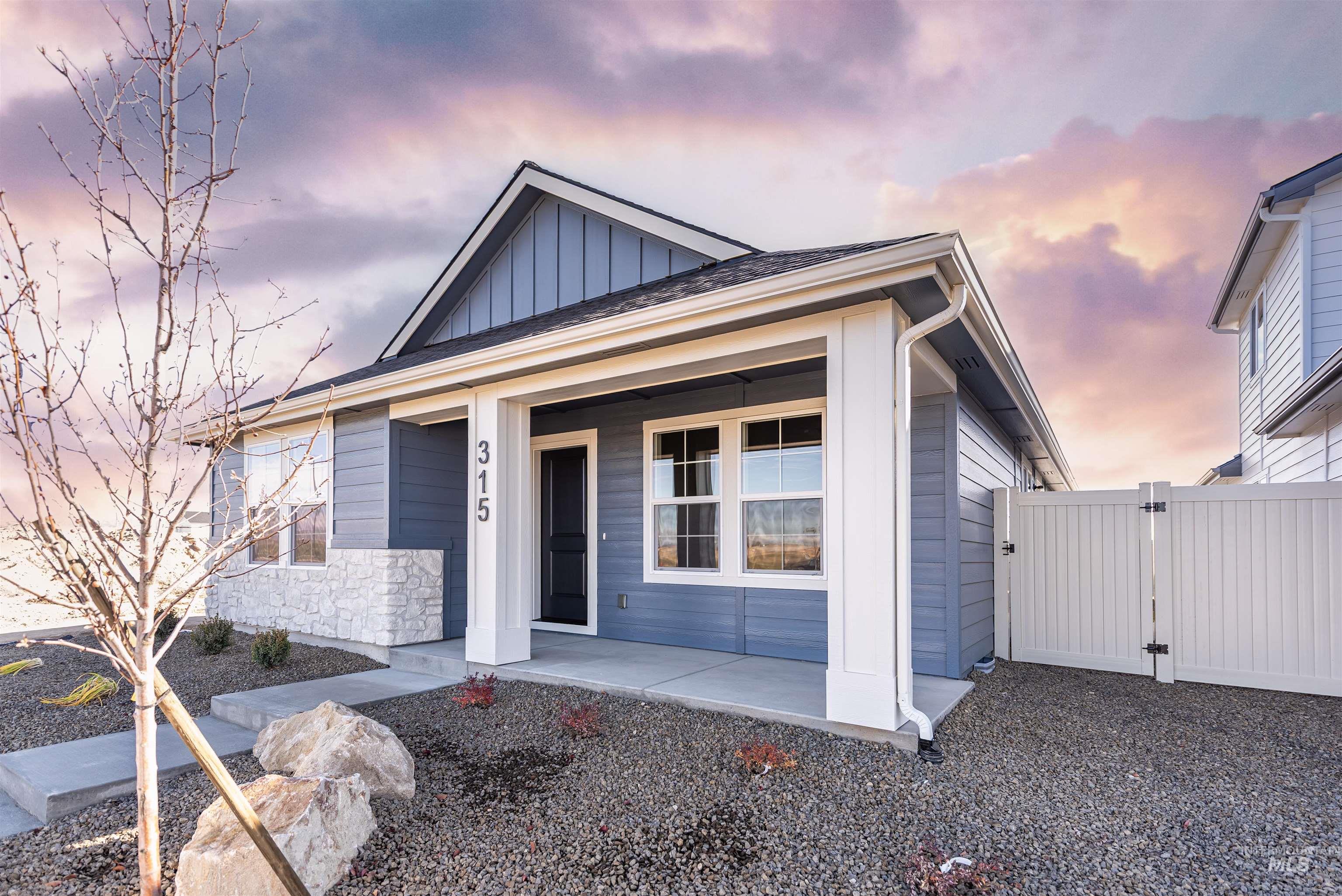 View of front of property featuring board and batten siding, a porch, a gate, and stone siding