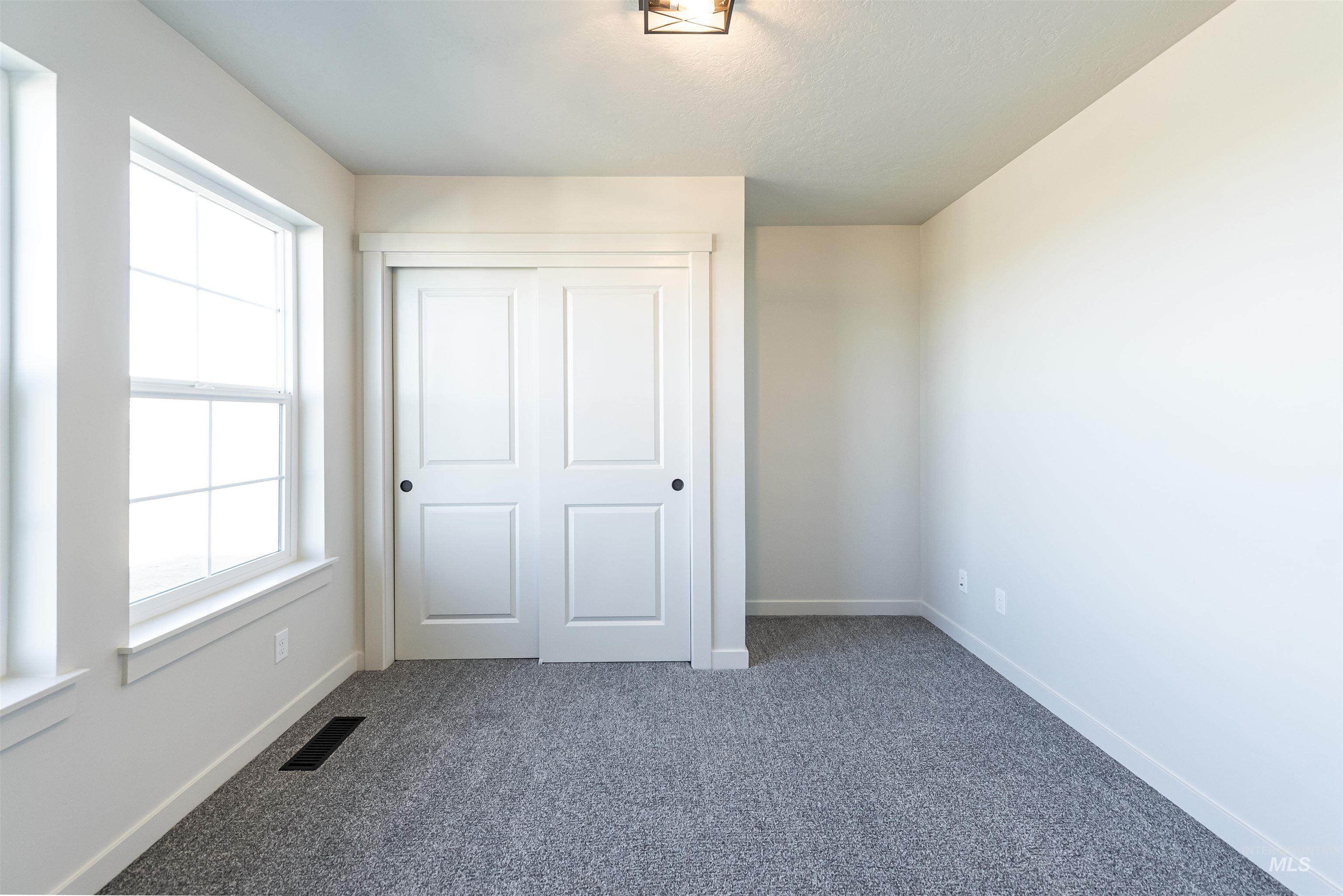 Unfurnished bedroom featuring dark colored carpet and a closet