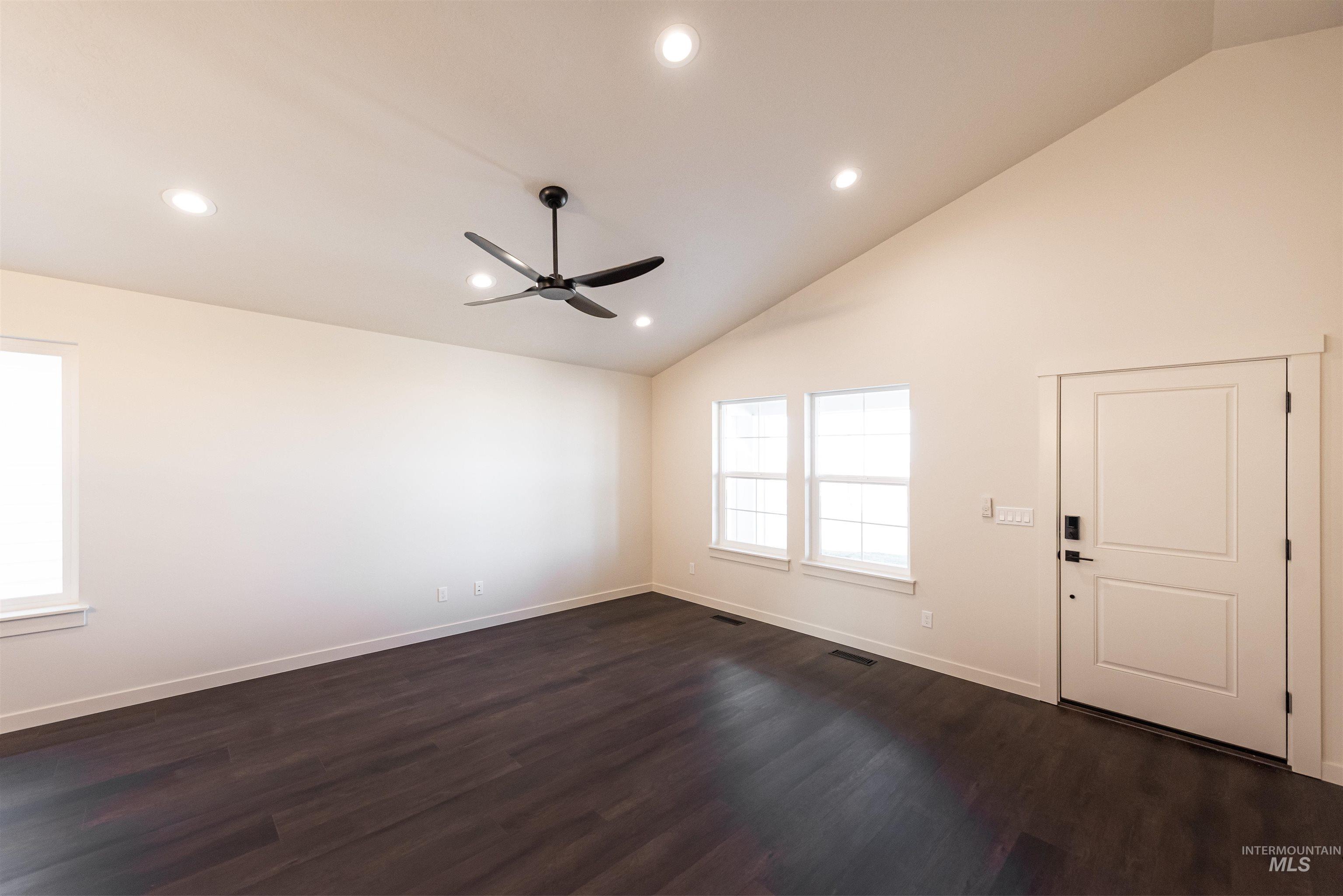 Entrance foyer with dark wood-type flooring, a ceiling fan, recessed lighting, and high vaulted ceiling