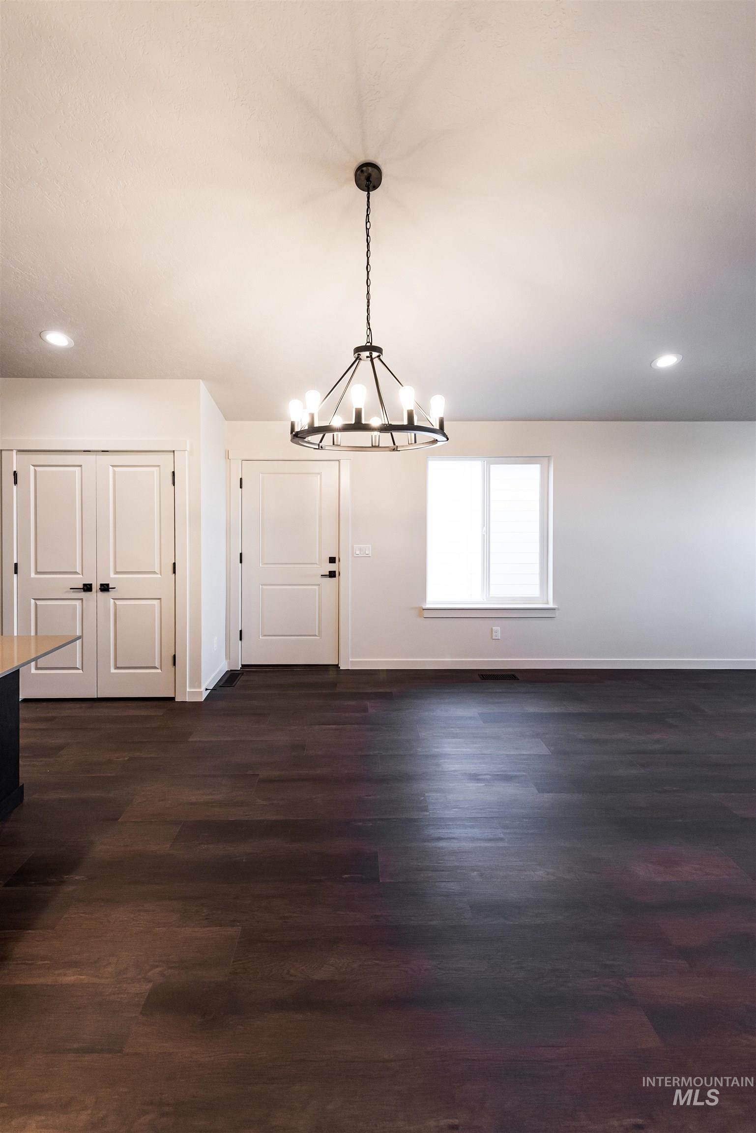 Unfurnished dining area featuring recessed lighting, dark wood finished floors, and a chandelier