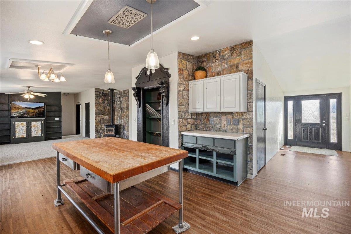 Kitchen with a wood stove, white cabinetry, dark wood finished floors, and light countertops