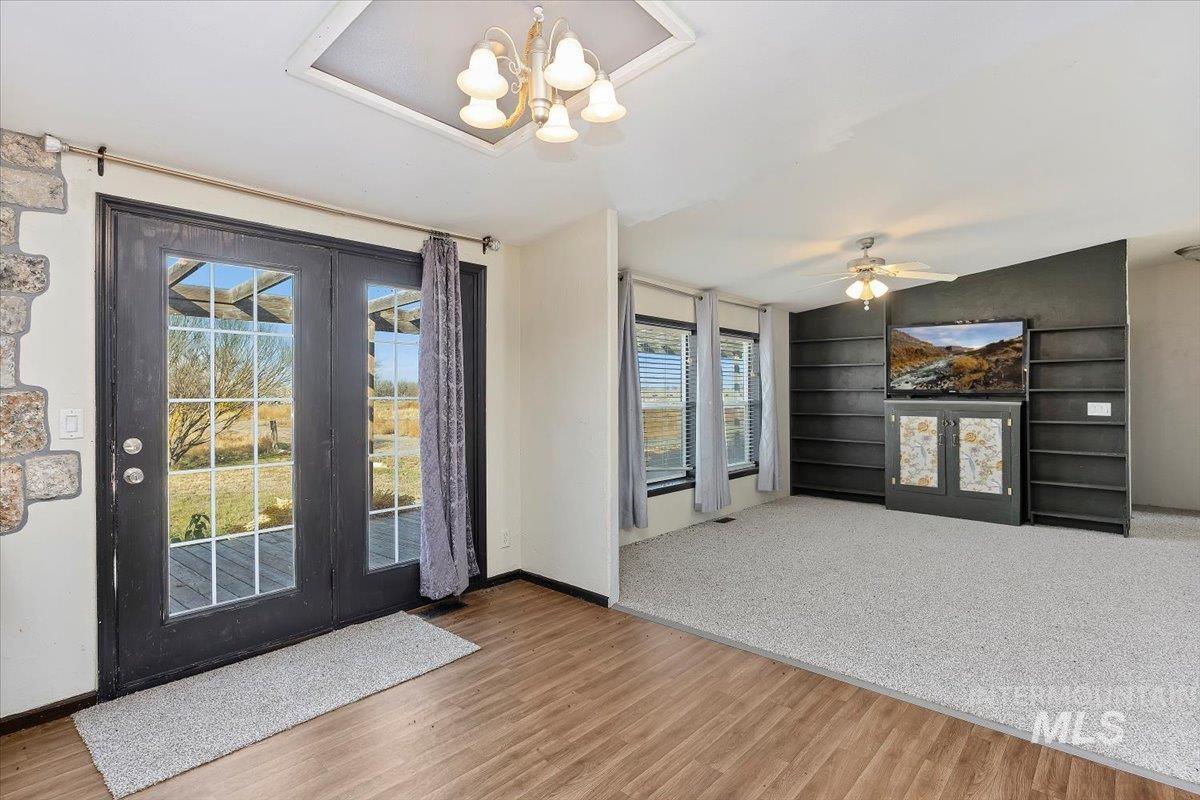 Entryway with plenty of natural light, a chandelier, and wood finished floors