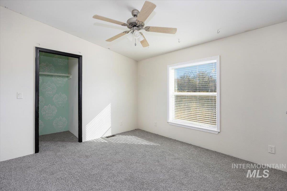 Unfurnished bedroom featuring a closet, ceiling fan, and carpet