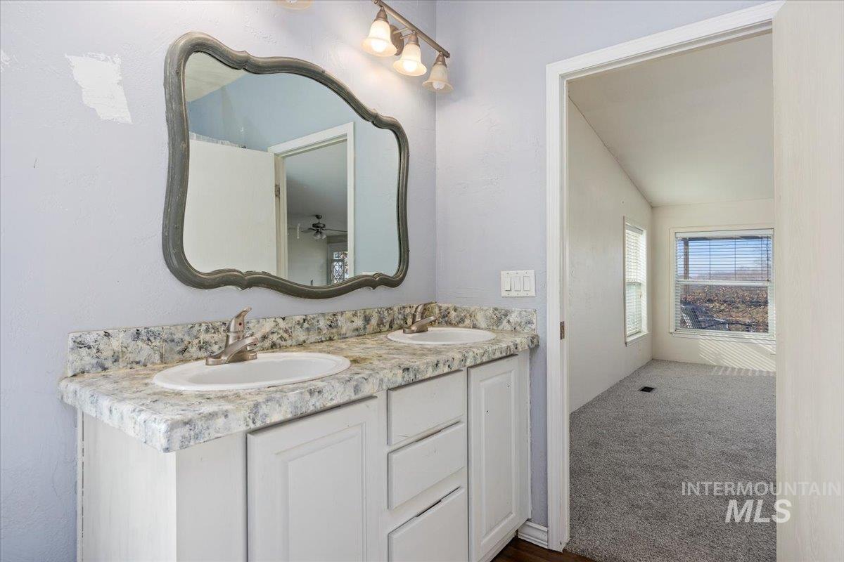 Full bathroom featuring double vanity and dark carpet