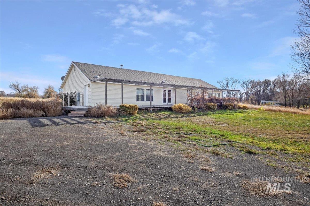 Rear view of house with roof with shingles and a wooden deck