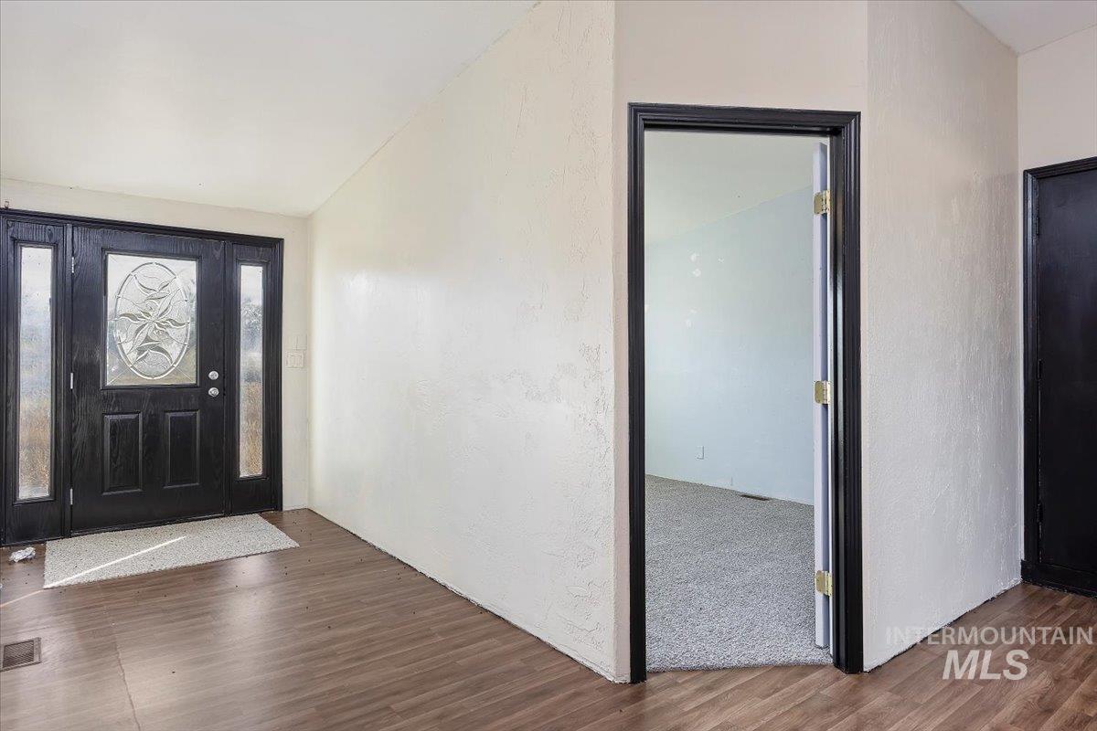 Foyer featuring wood finished floors and a textured wall