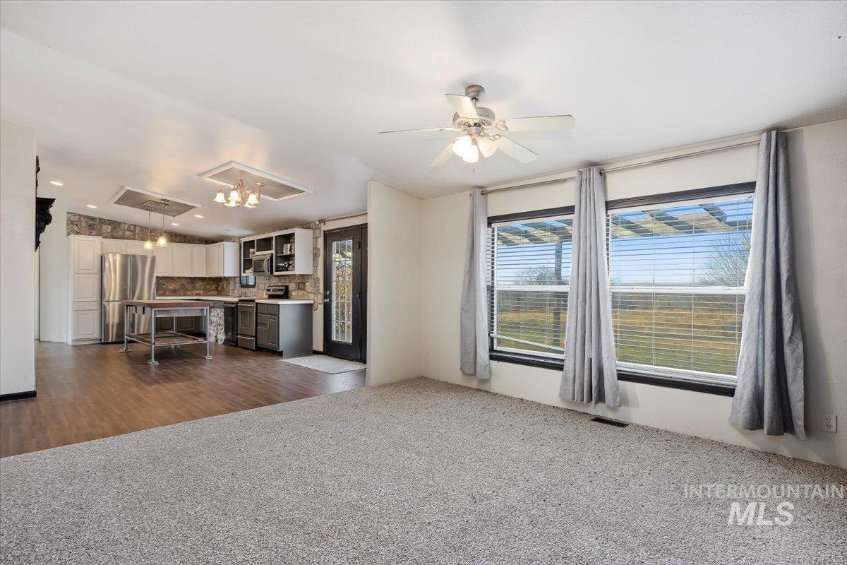 Unfurnished living room featuring lofted ceiling, dark carpet, ceiling fan, dark wood finished floors, and recessed lighting