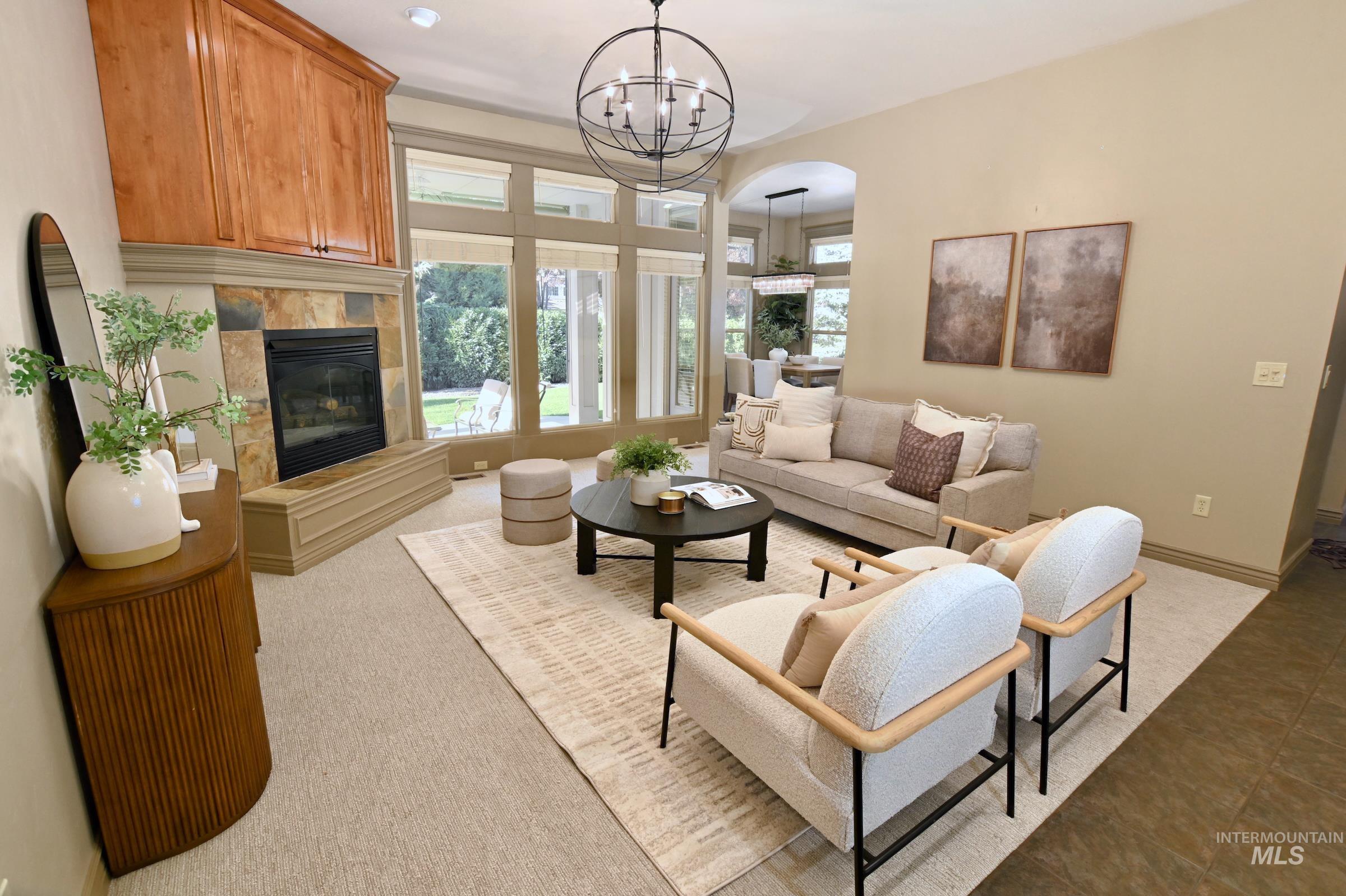 Living area featuring arched walkways, a fireplace, and a chandelier