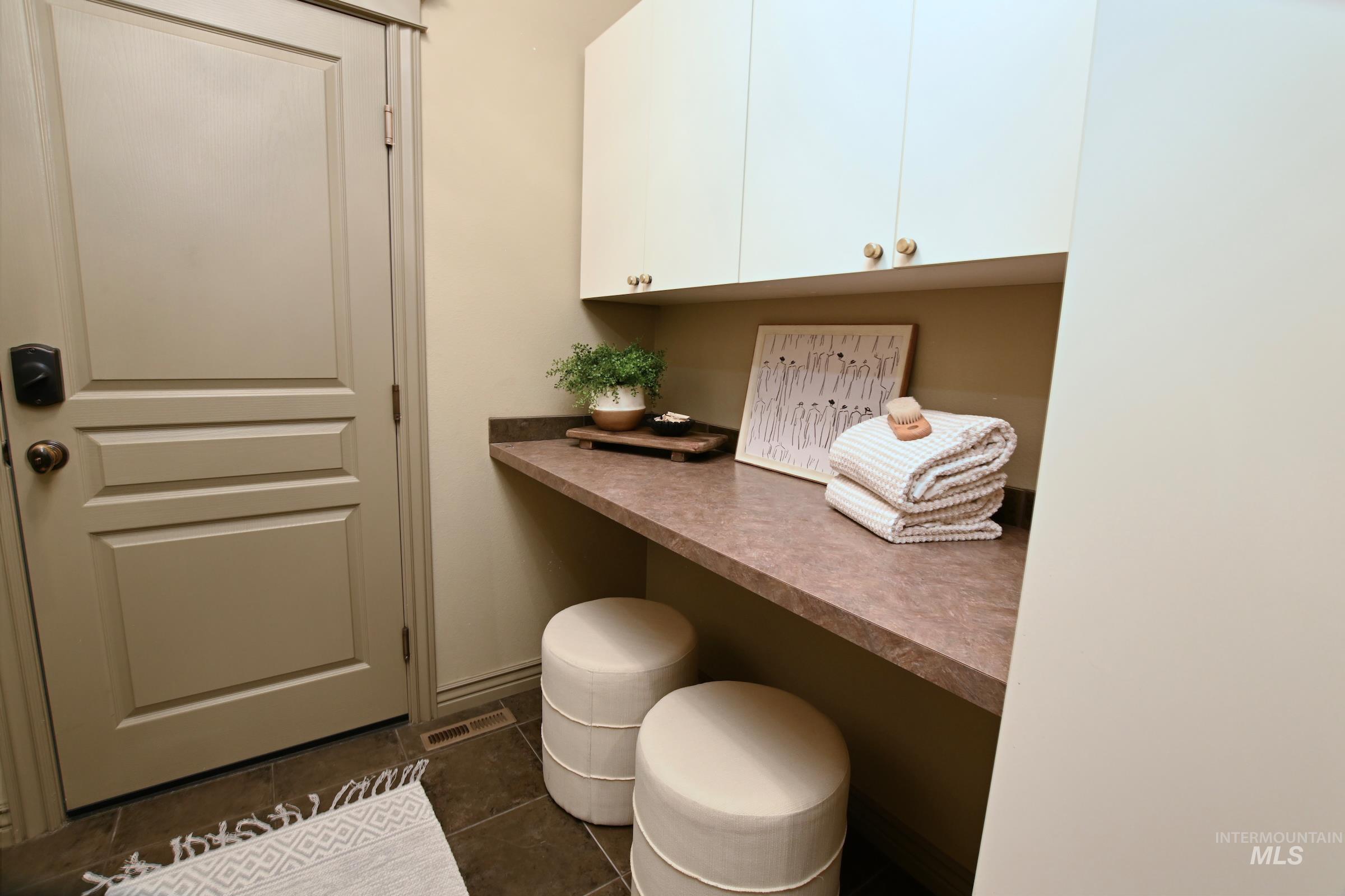 Office area with dark tile patterned flooring and baseboards