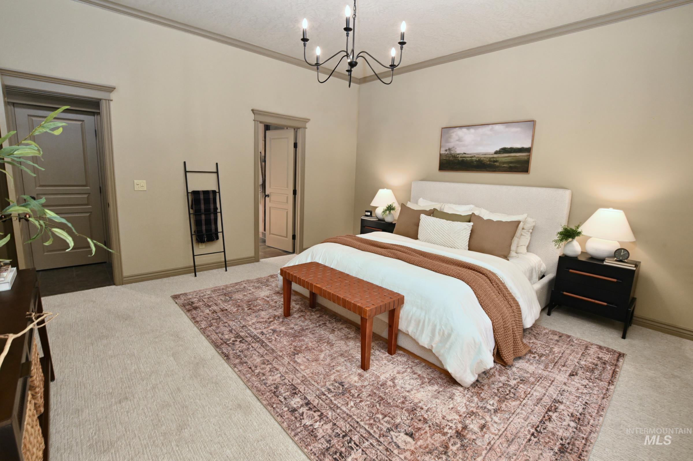 Carpeted bedroom with crown molding and a chandelier
