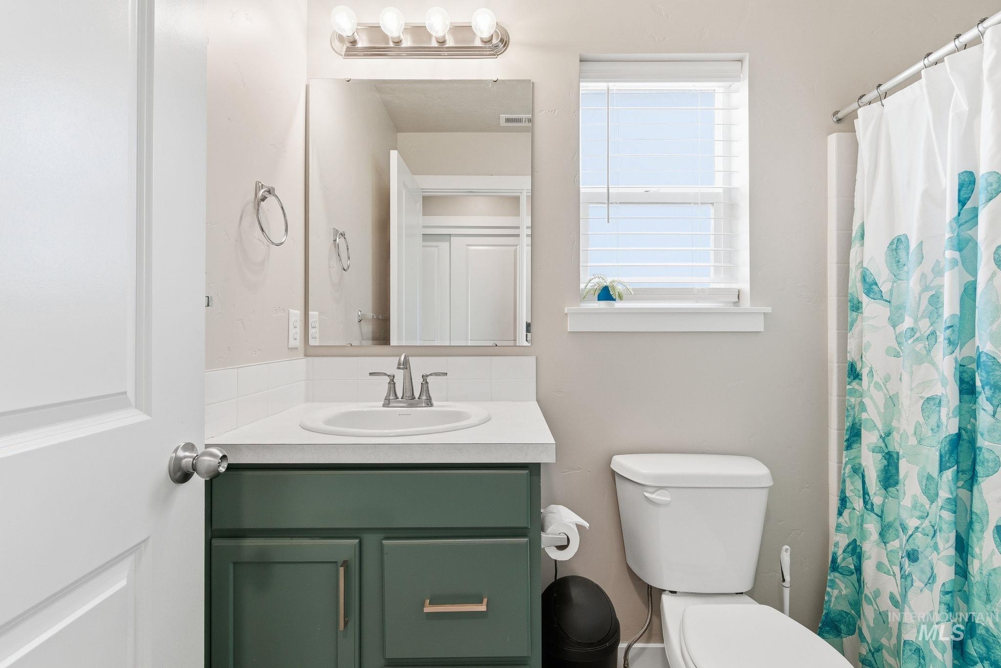 Bathroom featuring a shower with curtain and vanity