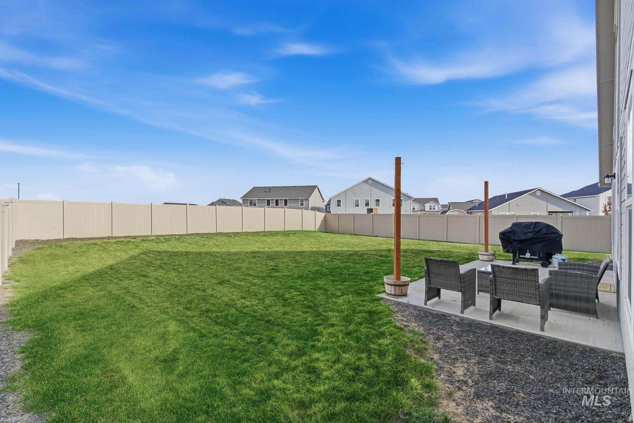 Fenced backyard with a patio area and a residential view