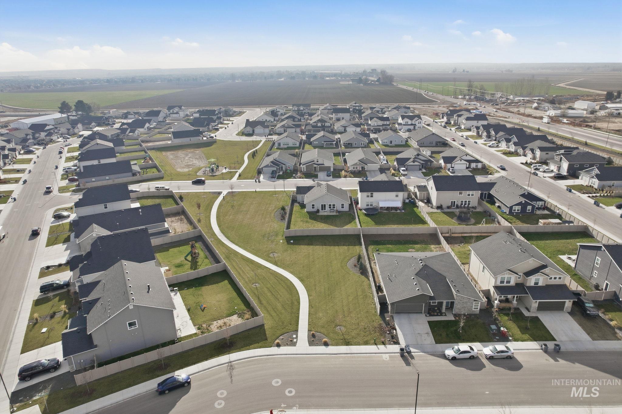 Aerial view of property and surrounding area with nearby suburban area