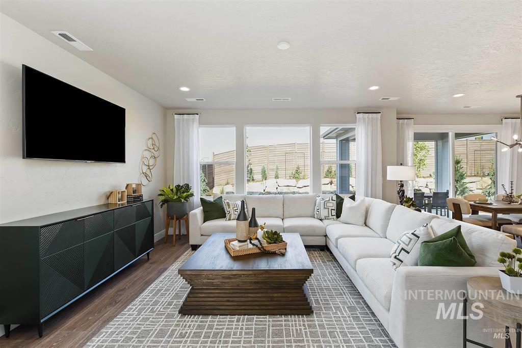 Living room with wood finished floors, recessed lighting, and a chandelier