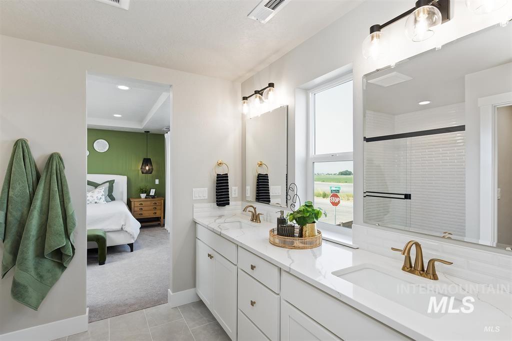 Full bath with double vanity, light colored carpet, ensuite bathroom, a stall shower, and light tile patterned flooring