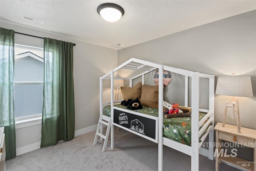Bedroom featuring light carpet and a textured ceiling