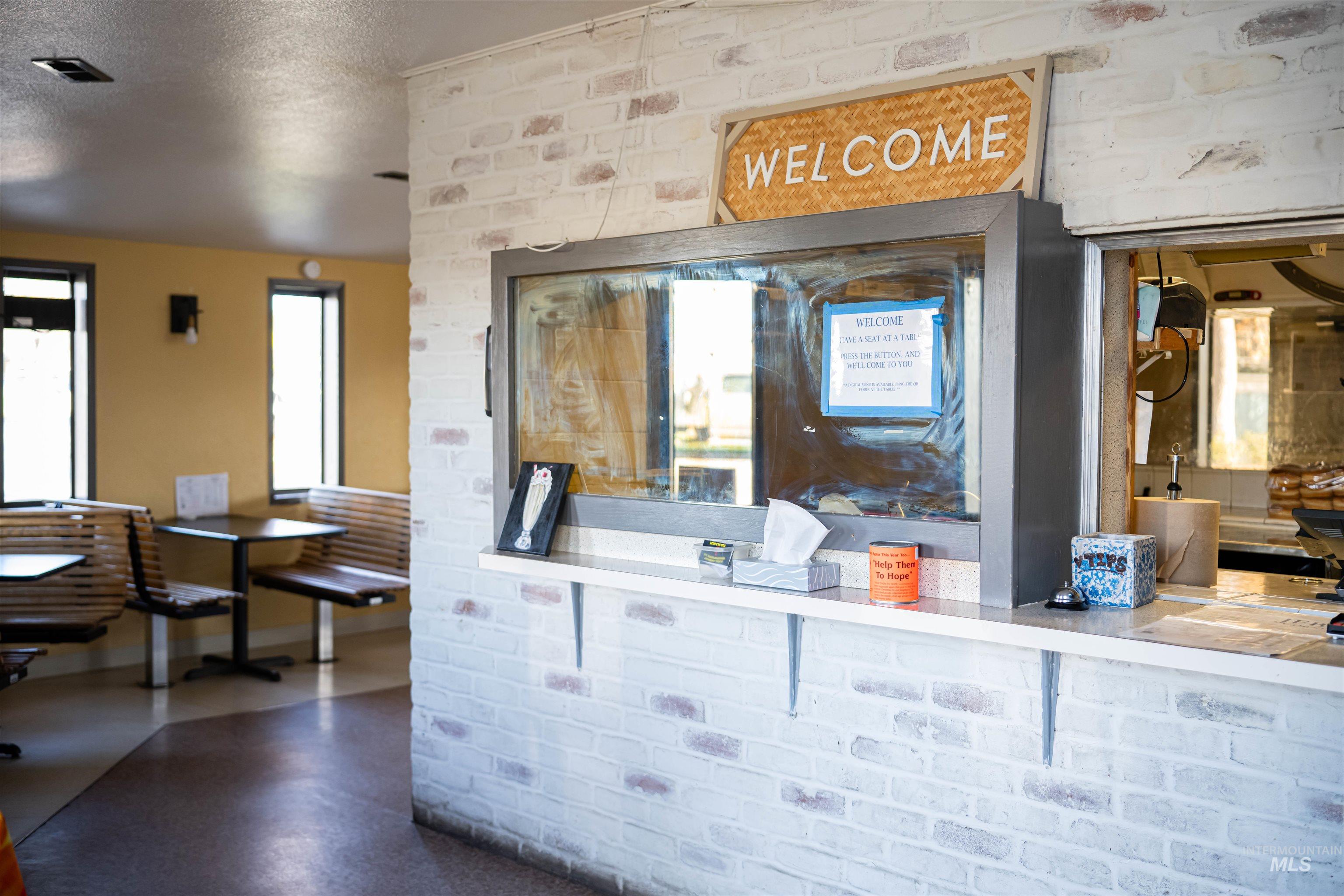Interior space featuring a textured ceiling and brick wall