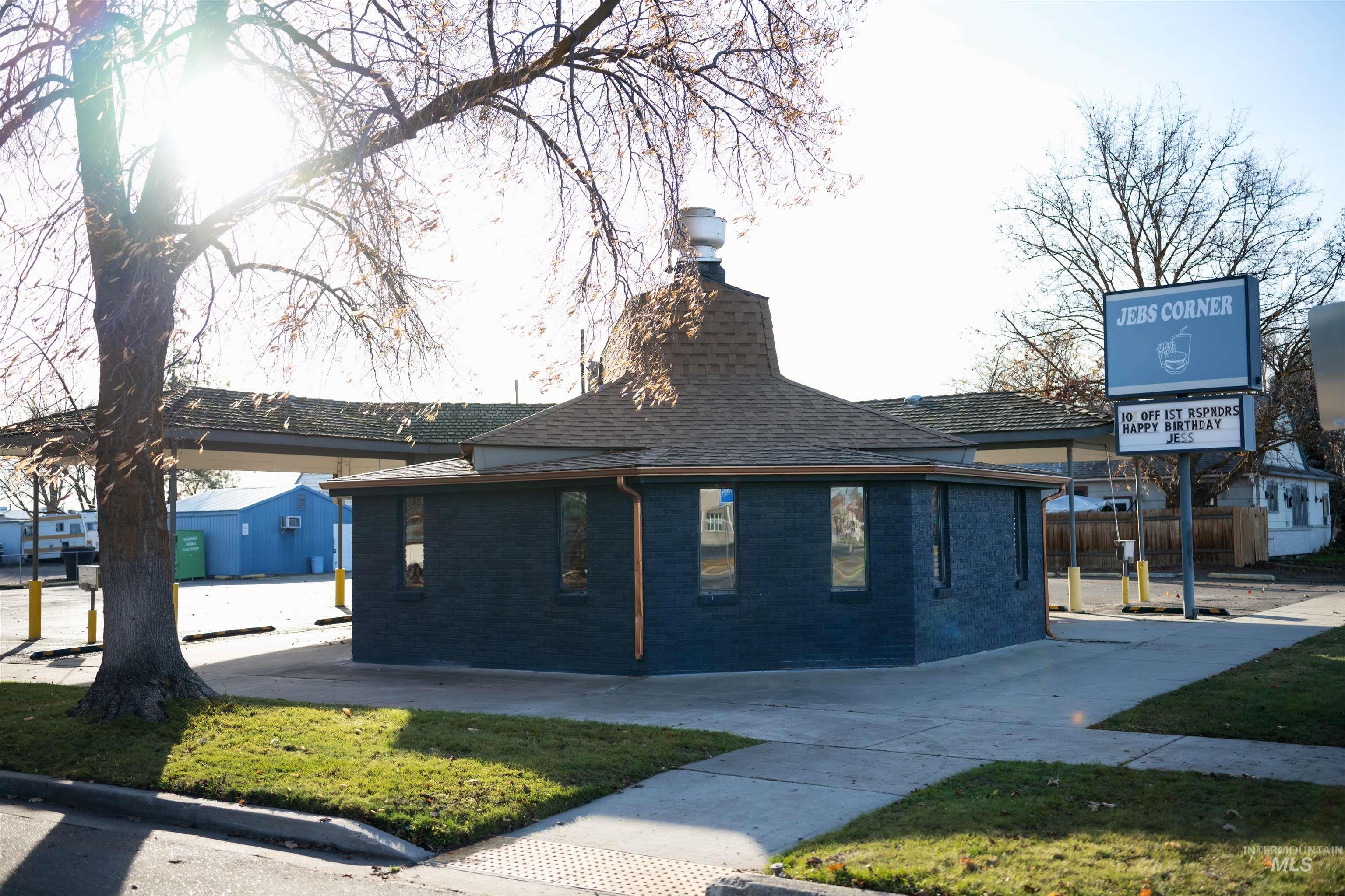 View of side of property featuring brick siding, a chimney, and a shingled roof