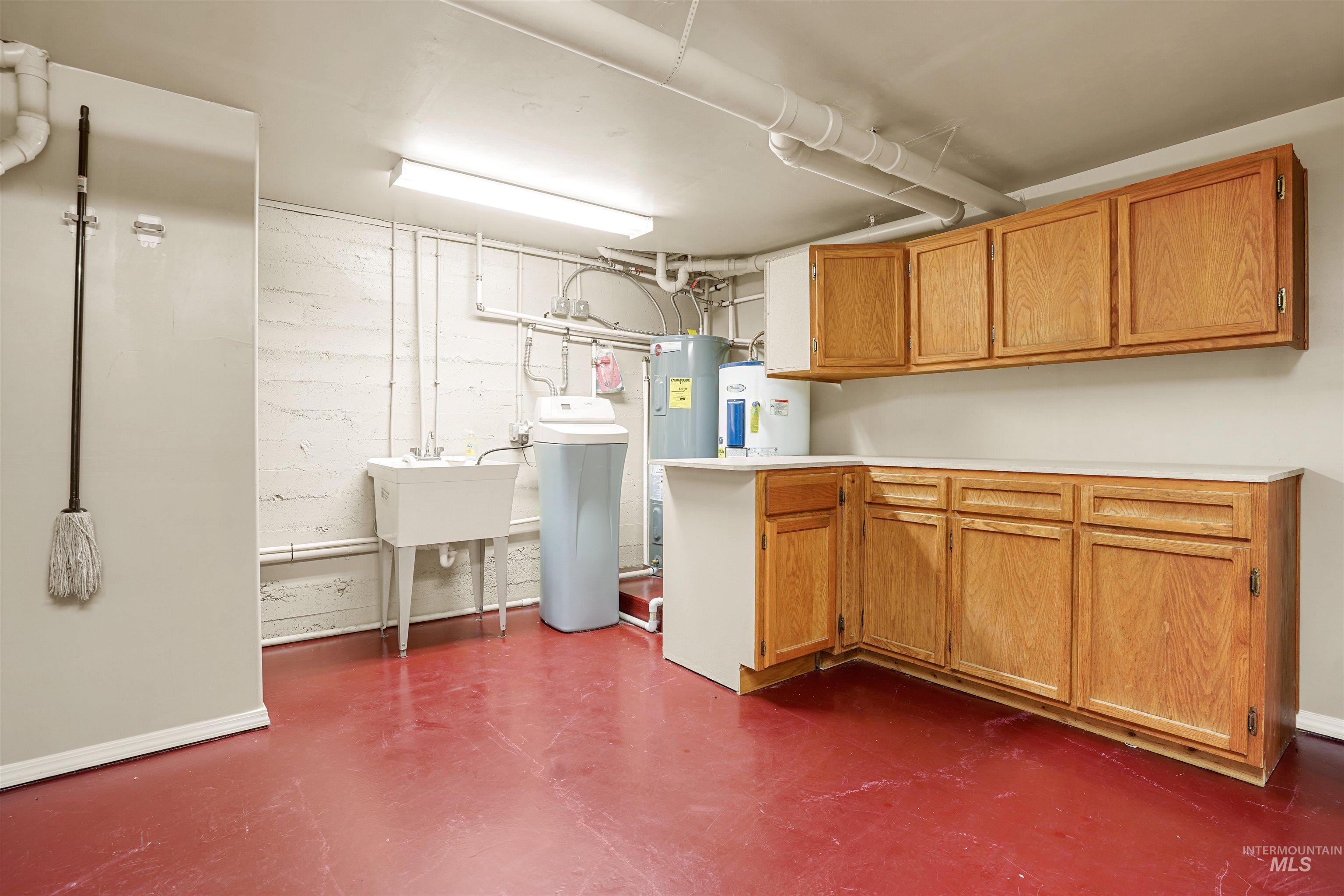 Finished basement featuring a water softener system and electric water heater