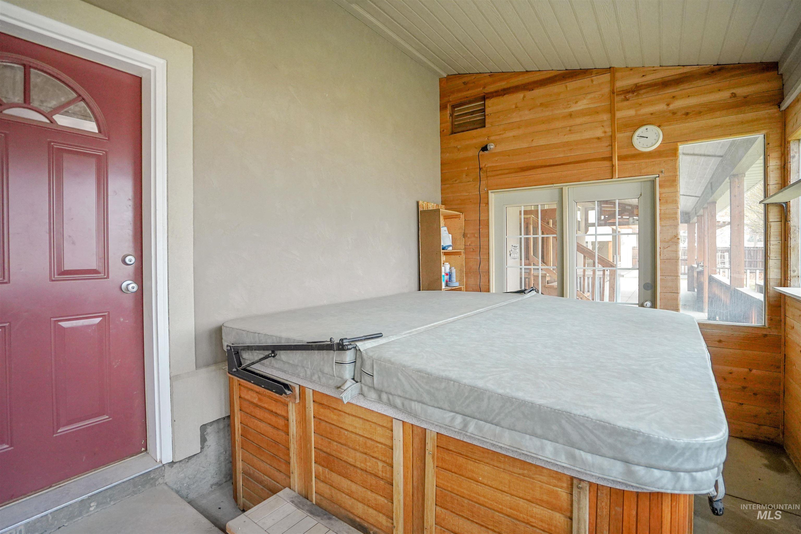 Exterior space with lofted ceiling, a jacuzzi, and plenty of natural light