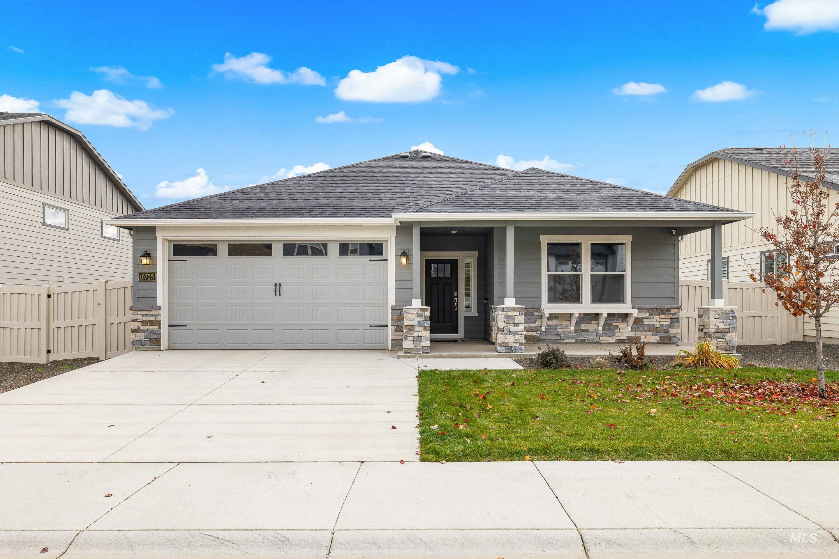 Craftsman-style home with covered porch, a shingled roof, stone siding, driveway, and an attached garage