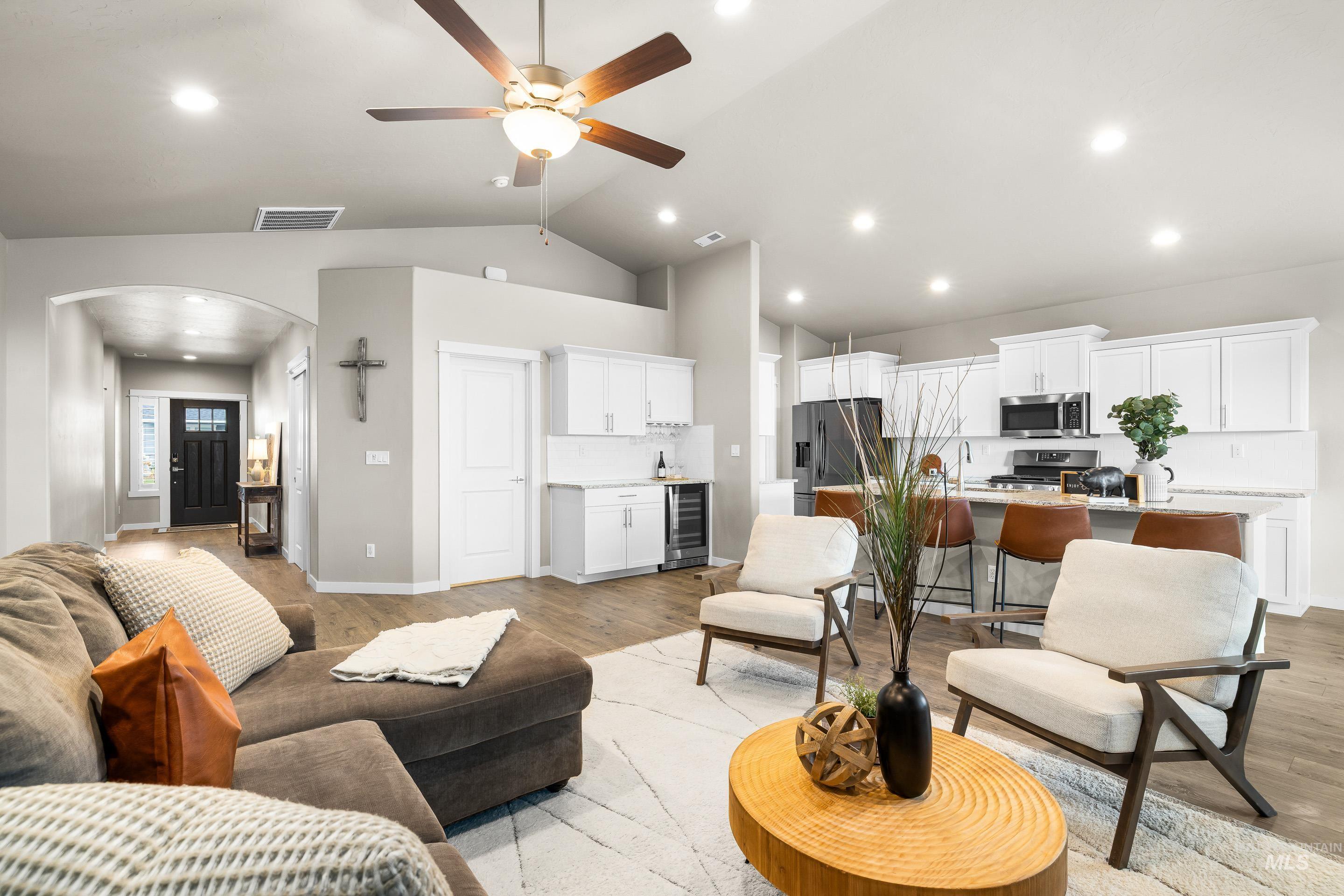 Living area featuring ceiling fan, recessed lighting, light wood-type flooring, beverage cooler, and lofted ceiling