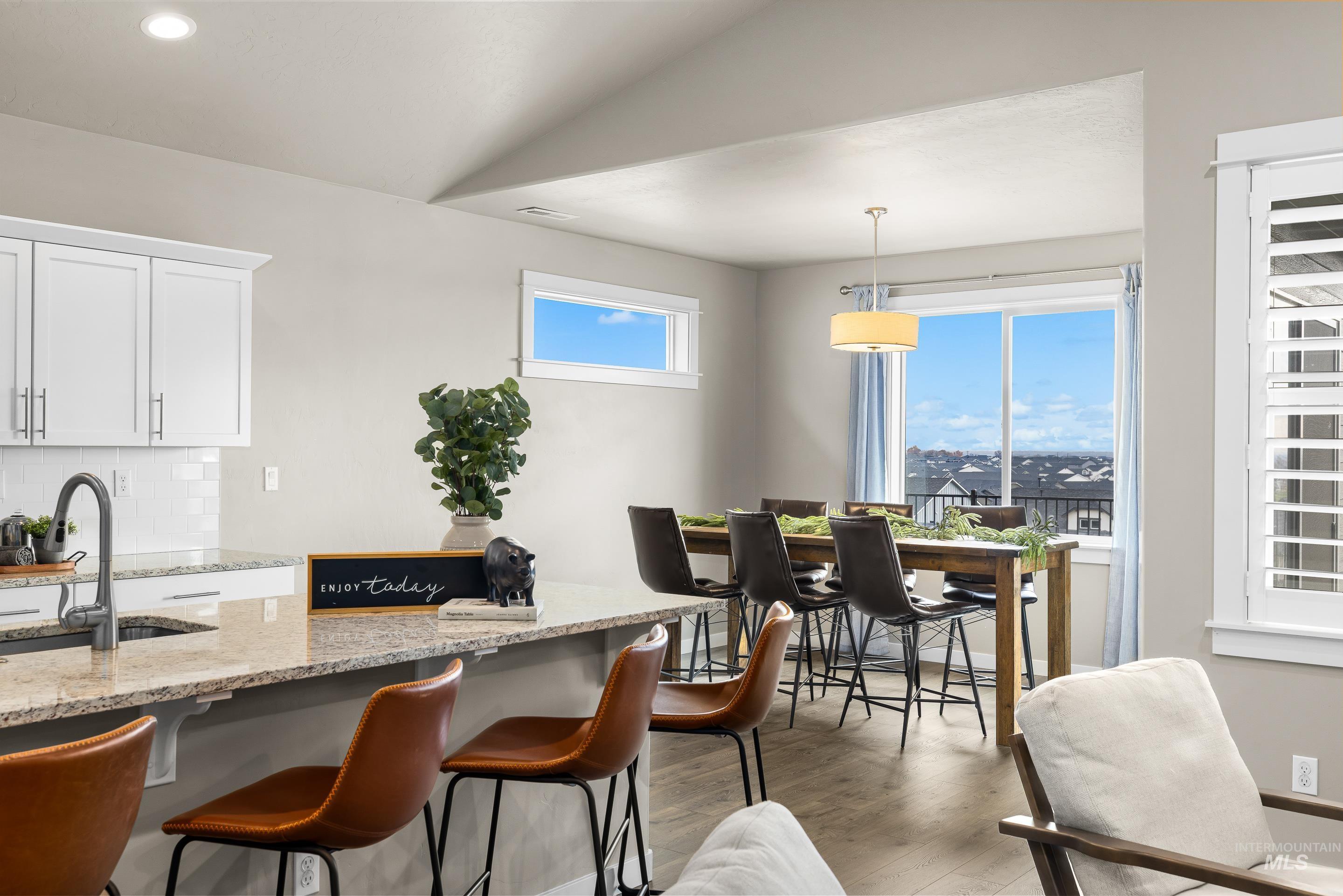 Dining room with vaulted ceiling and light wood finished floors