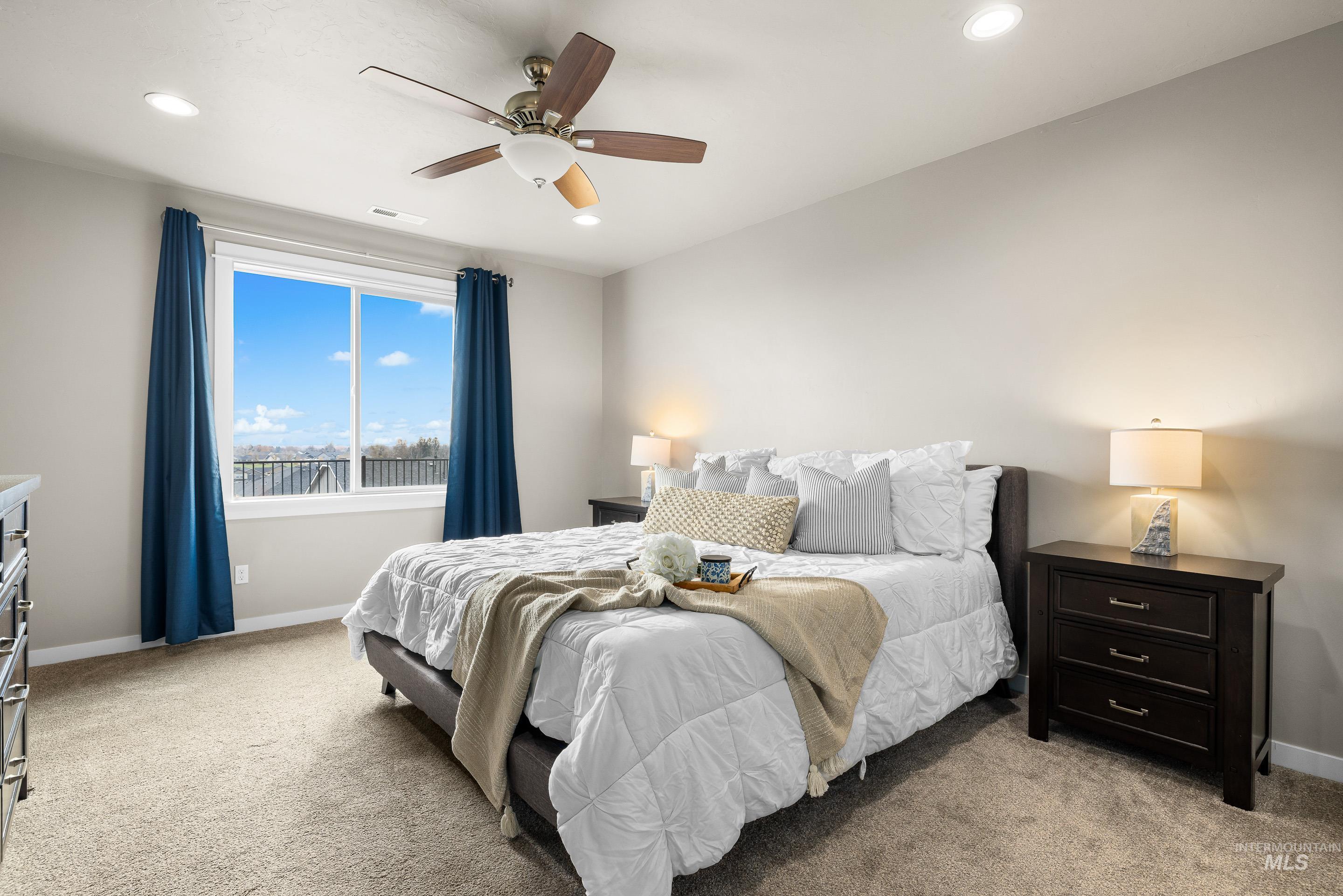 Bedroom with light carpet, ceiling fan, and recessed lighting
