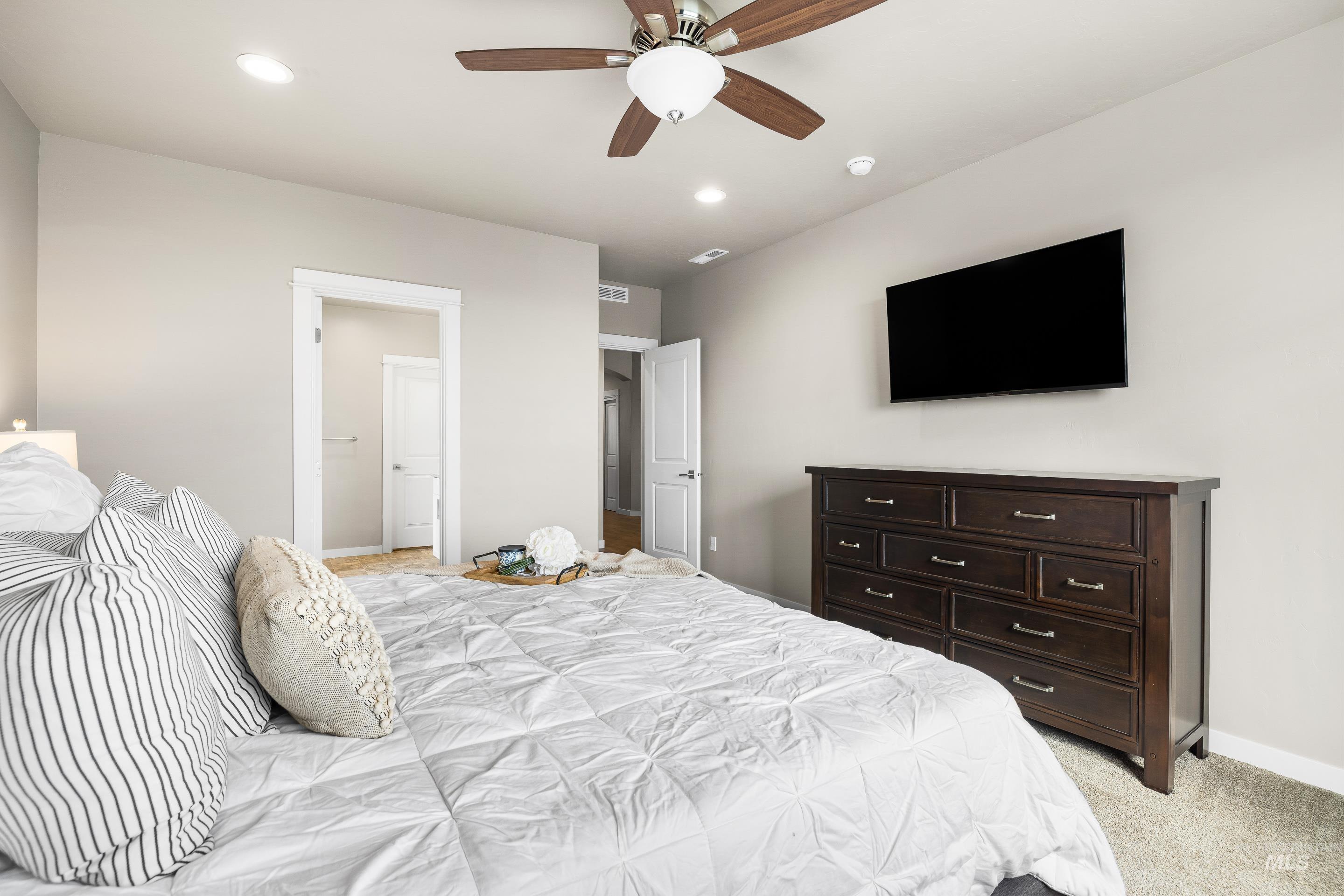 Bedroom featuring light colored carpet, a ceiling fan, and recessed lighting