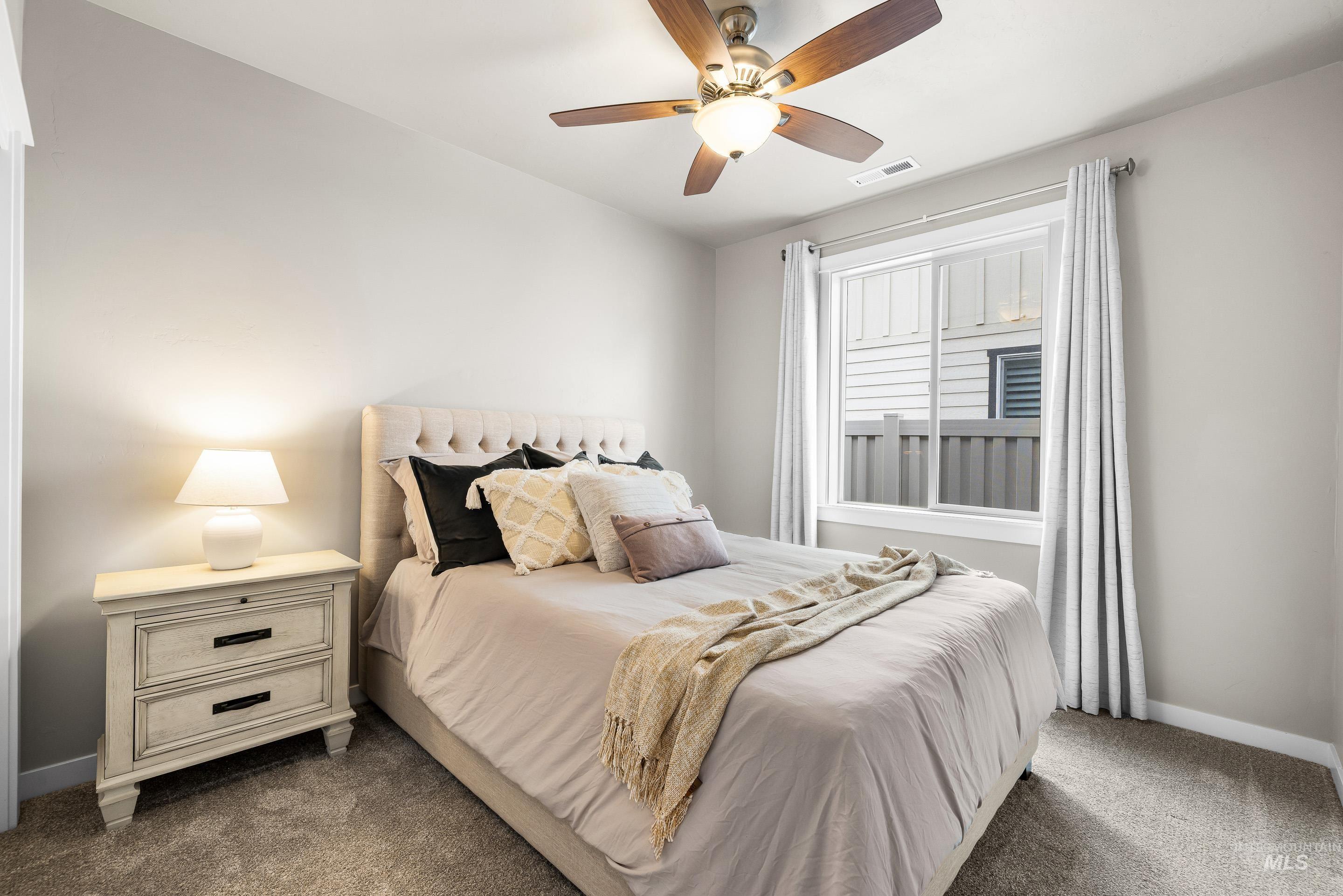 Bedroom featuring ceiling fan and dark colored carpet