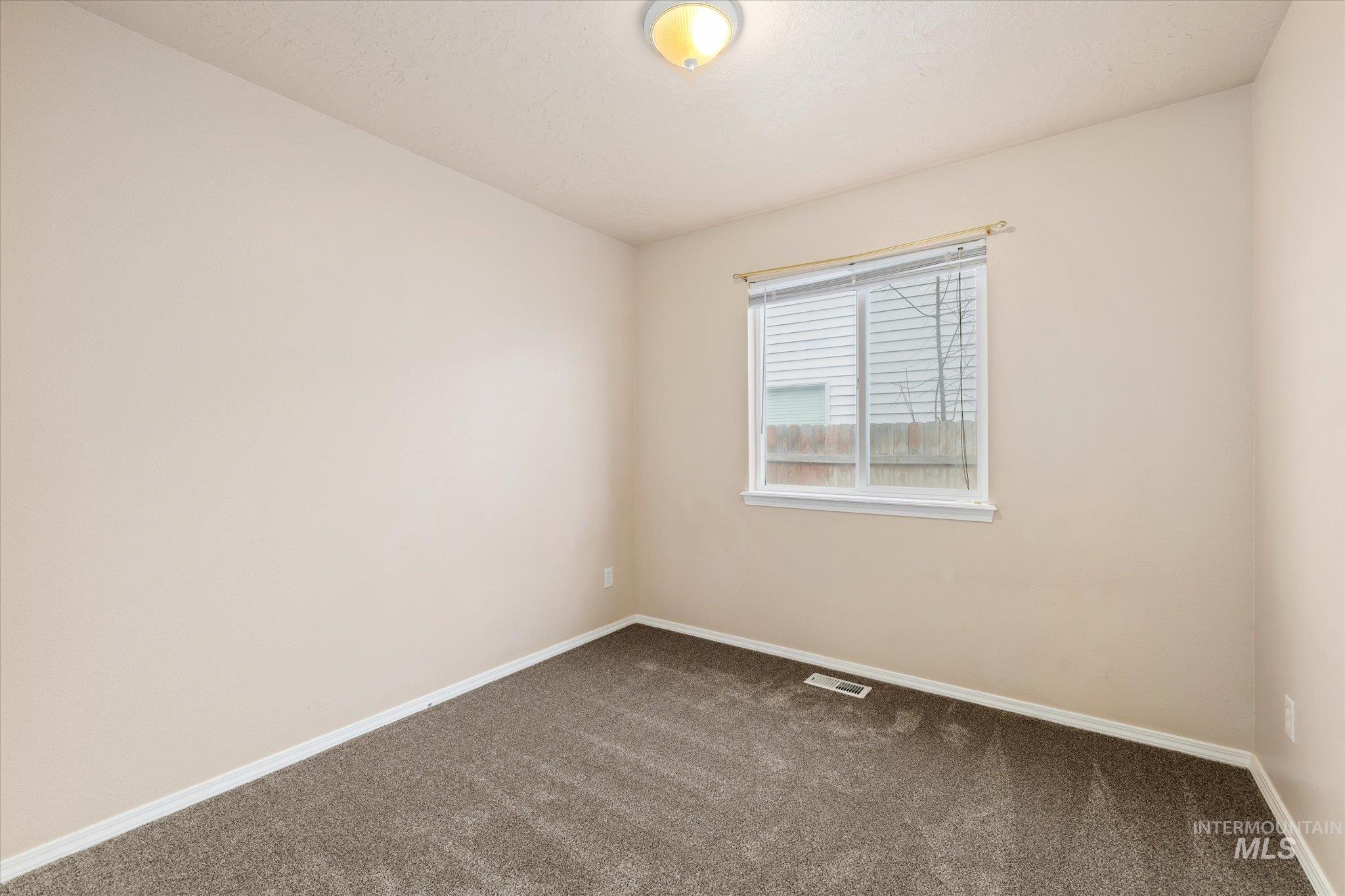 Carpeted empty room with baseboards