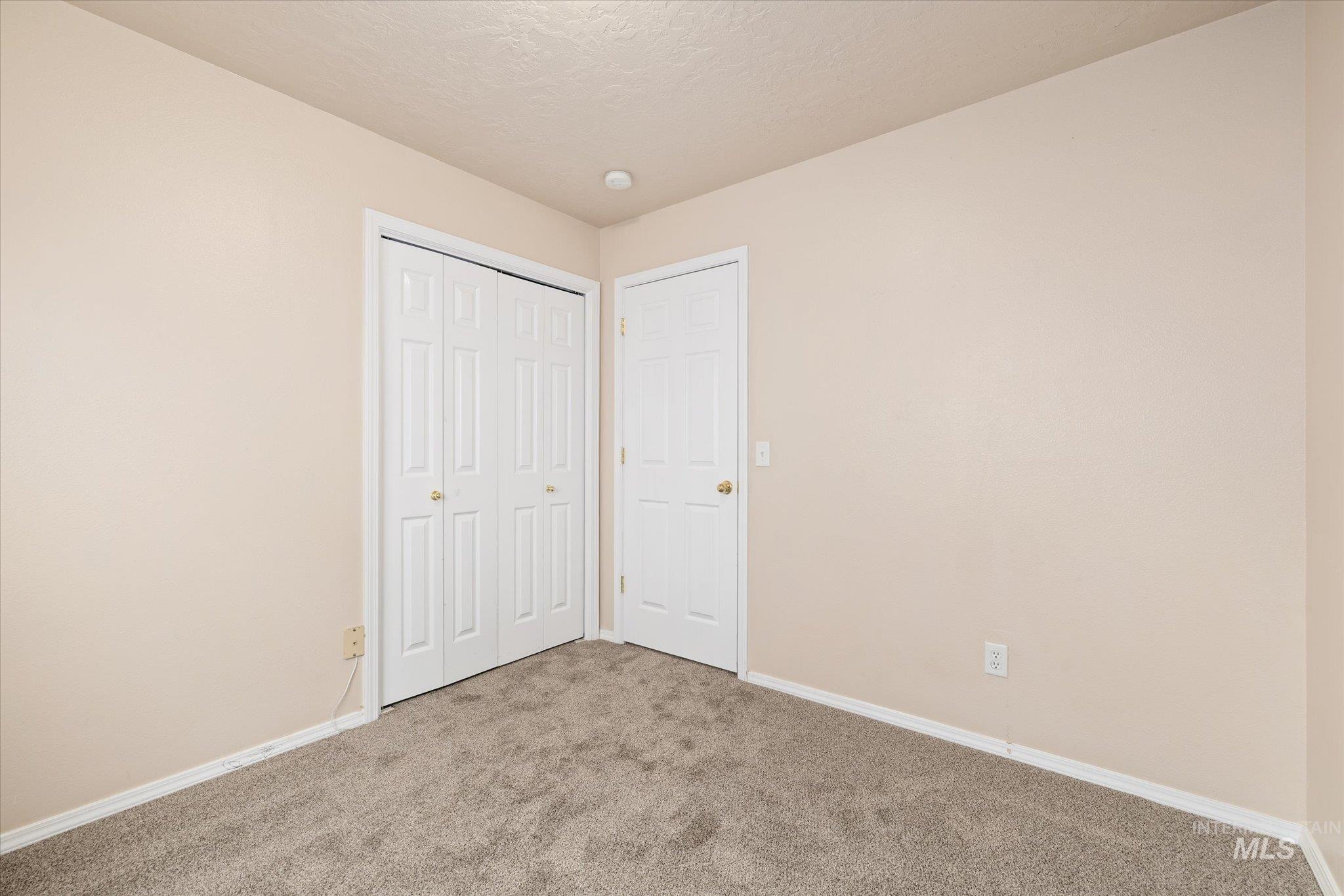 Unfurnished bedroom featuring carpet flooring, a closet, and a textured ceiling