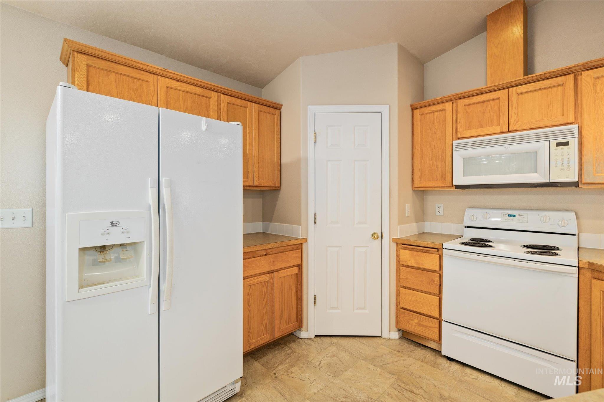 Kitchen featuring white appliances and light countertops