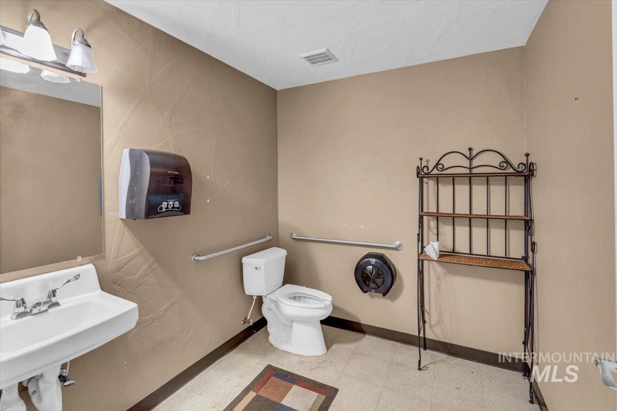 Half bathroom featuring toilet and light flooring
