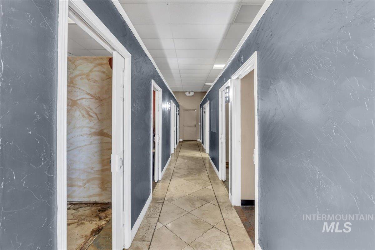 Hallway with a textured wall and light tile patterned floors